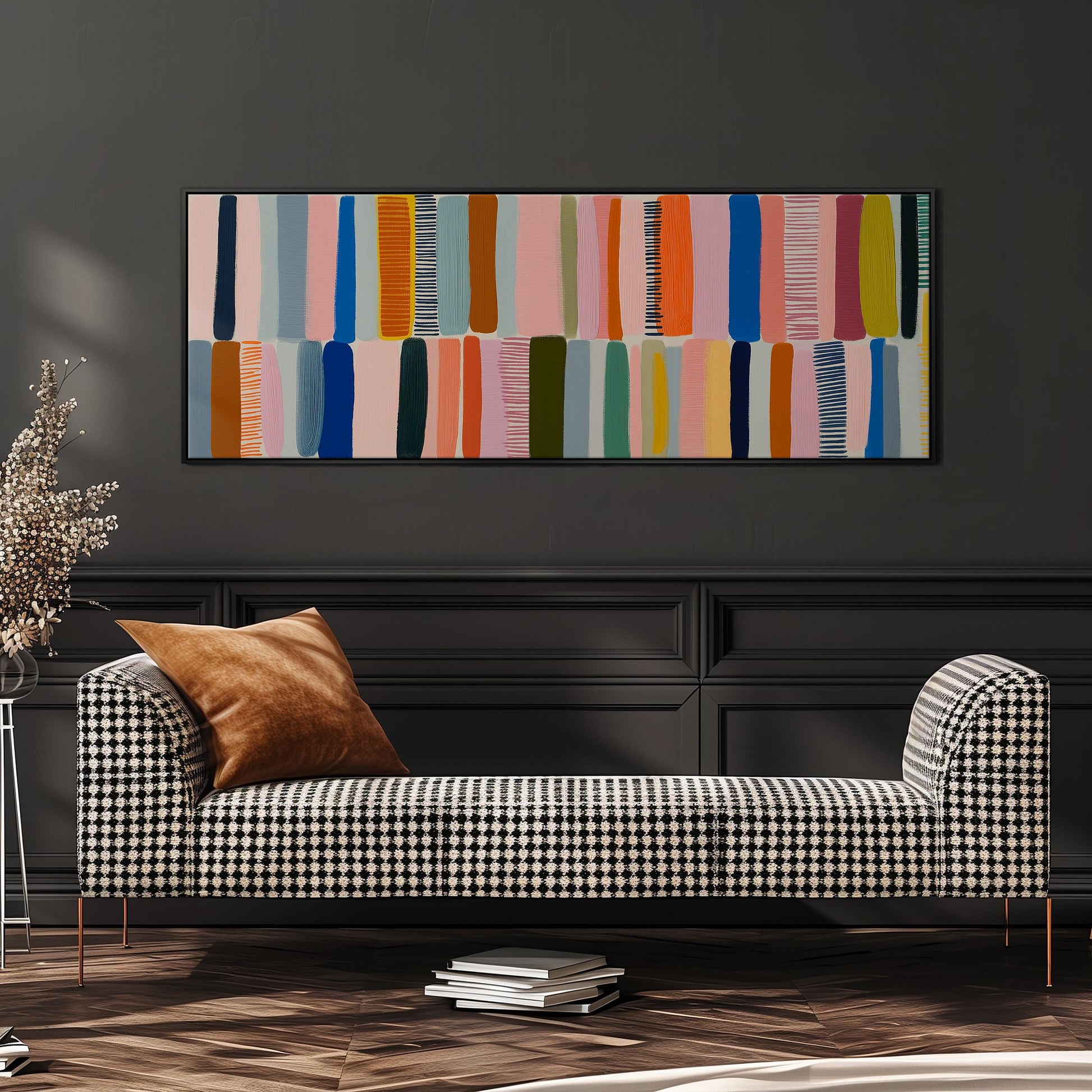 a modern living room with a black and white checkered sofa, a stack of books, and a large abstract painting on the wall.