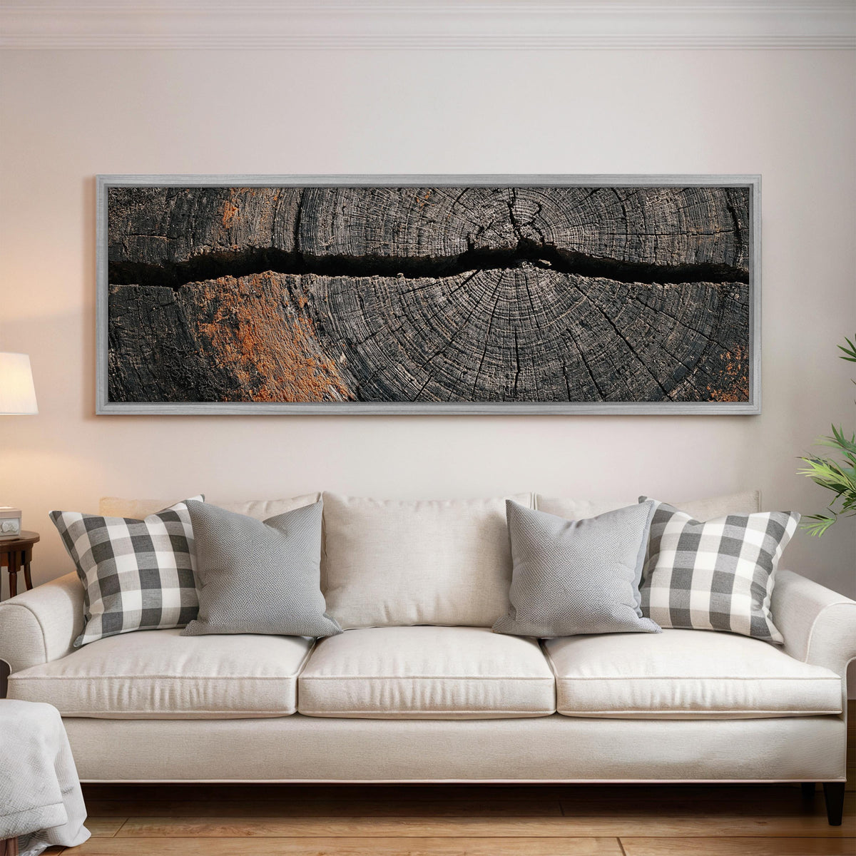 Cracked weathered wood ring panoramic canvas print above a white sofa in a bright living room