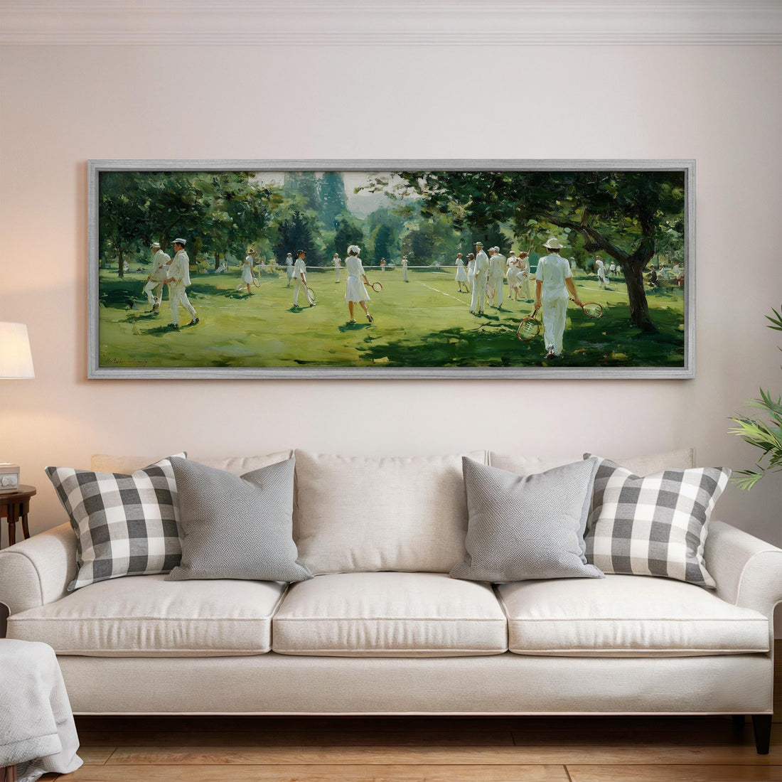 a large painting of people playing tennis on a grass court, with a bowl of fruit and a vase of flowers on the table in front of it.