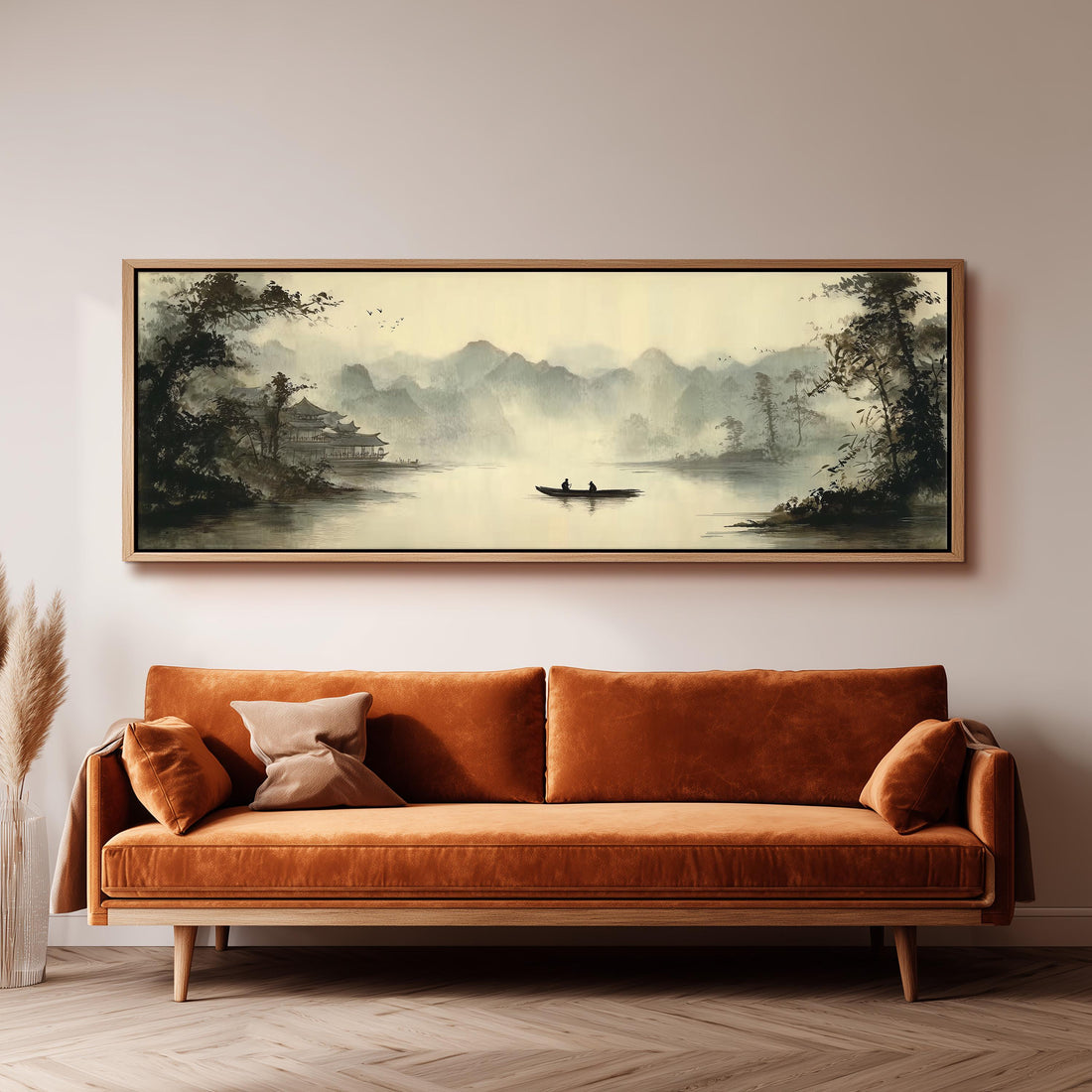 a large, framed painting of a serene landscape with a boat on a lake, hanging on a wall above a brown sofa.