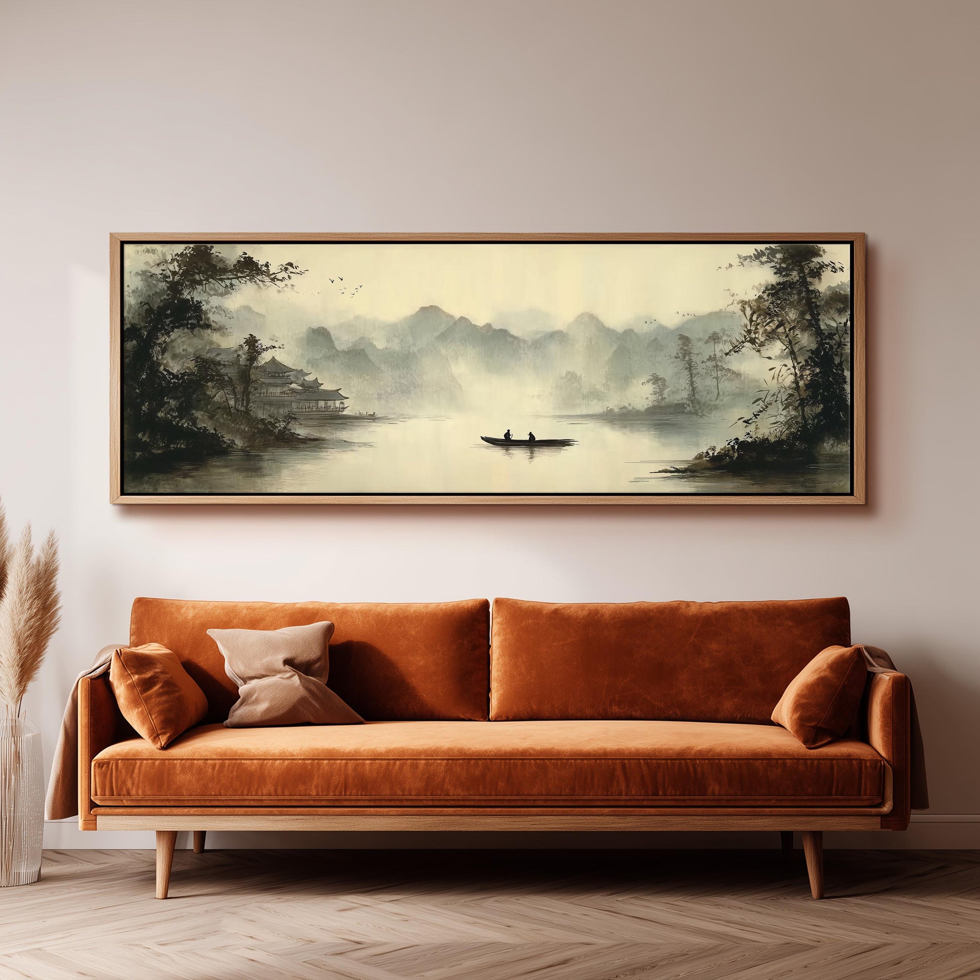 a large, framed painting of a serene landscape with a boat on a lake, hanging on a wall above a brown sofa.