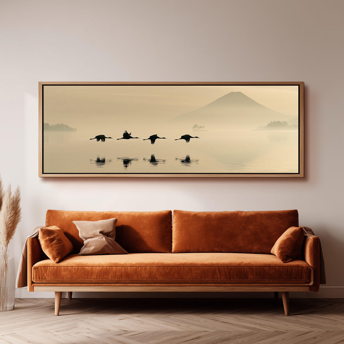 Birds flying low over a lake below Mount Fuji long horizontal canvas print above a sofa in a living room