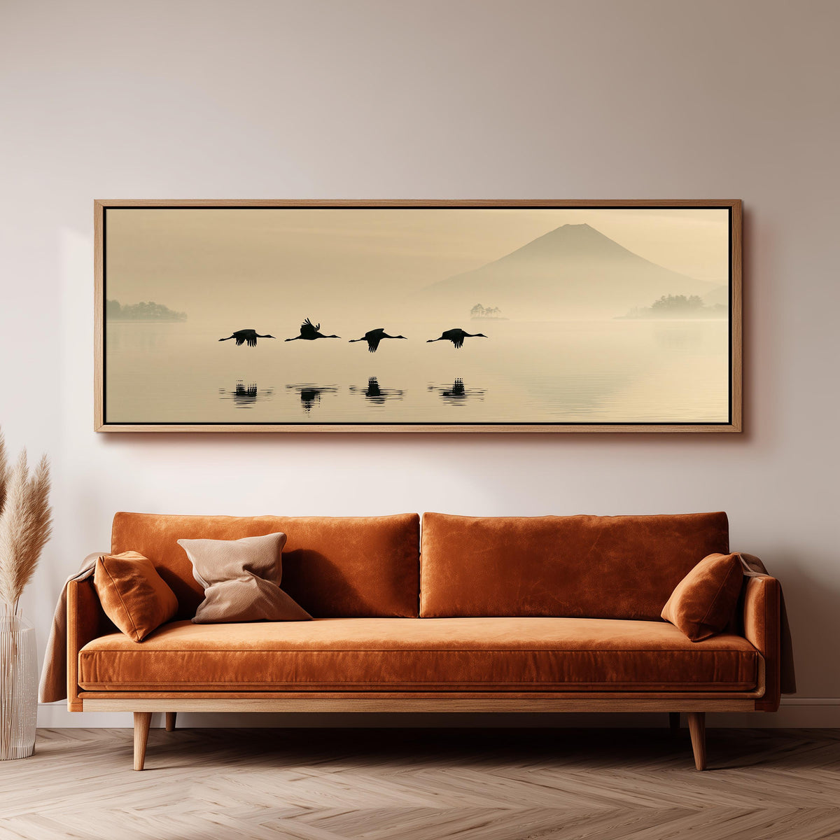 Birds flying low over a lake below Mount Fuji panoramic canvas print above a sofa in a living room