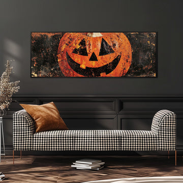 Rustic distressed jack-o'-lantern long horizontal canvas print above a sofa in a living room
