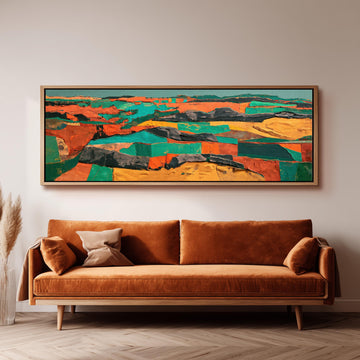 Abstract patchwork terrain in orange and teal long horizontal canvas print above a sofa in a living room