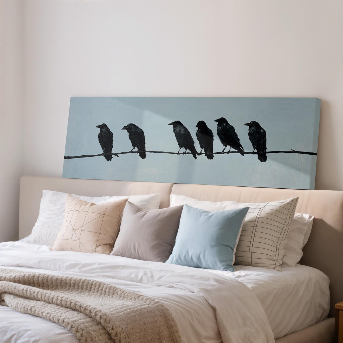 Ravens spaced along a wire wide panoramic canvas print above a bed in a bedroom