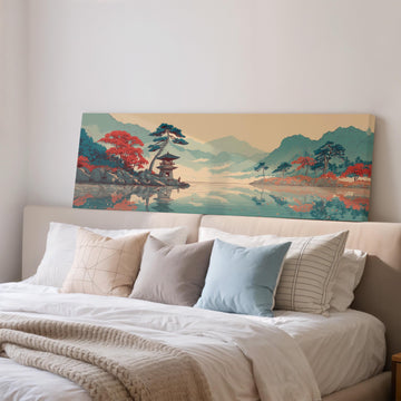 a large painting of a serene landscape with mountains, trees, and a temple, hanging above a bed with white pillows and a gray blanket.