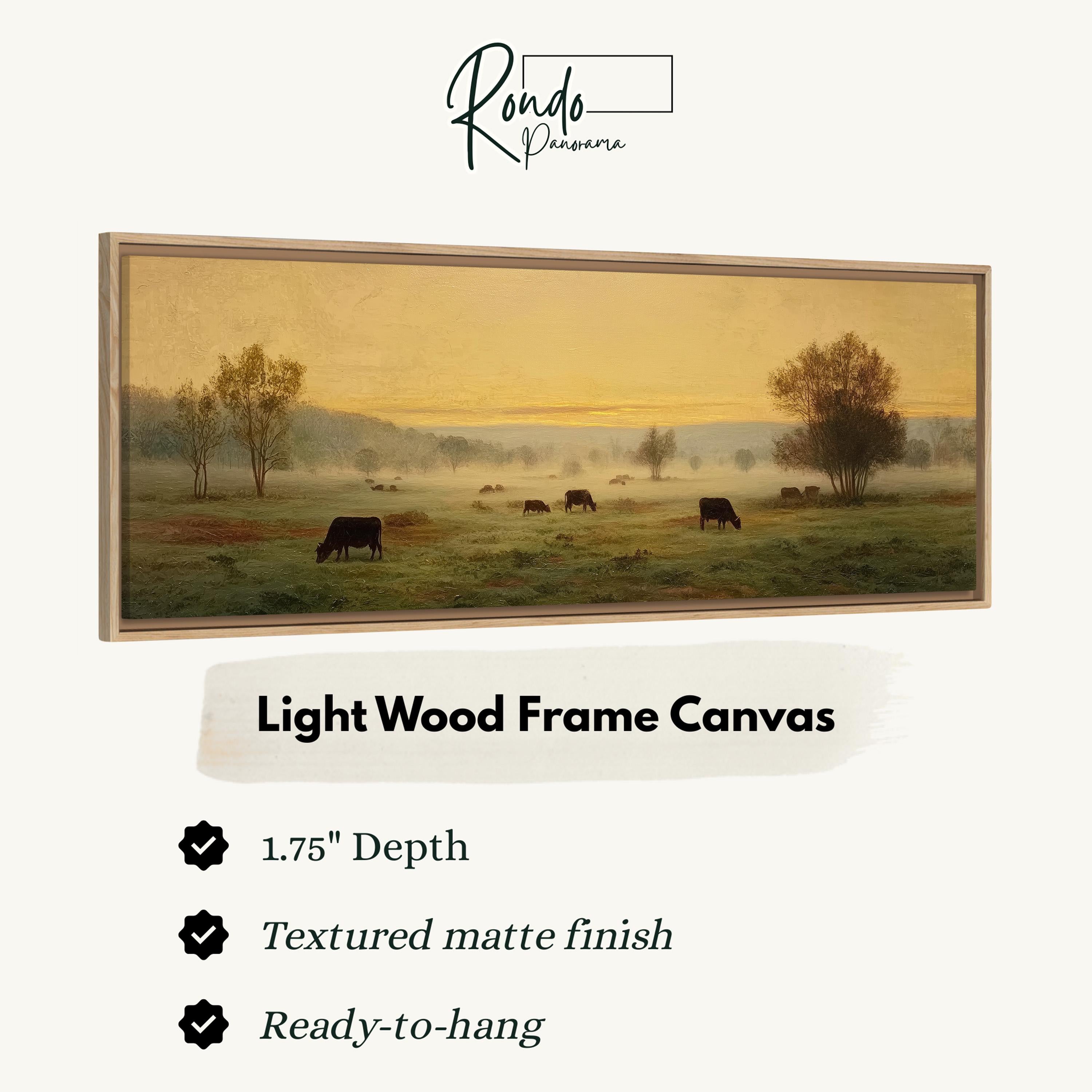 The image is a light wood frame canvas depicting a pastoral scene with cows grazing in a field.
