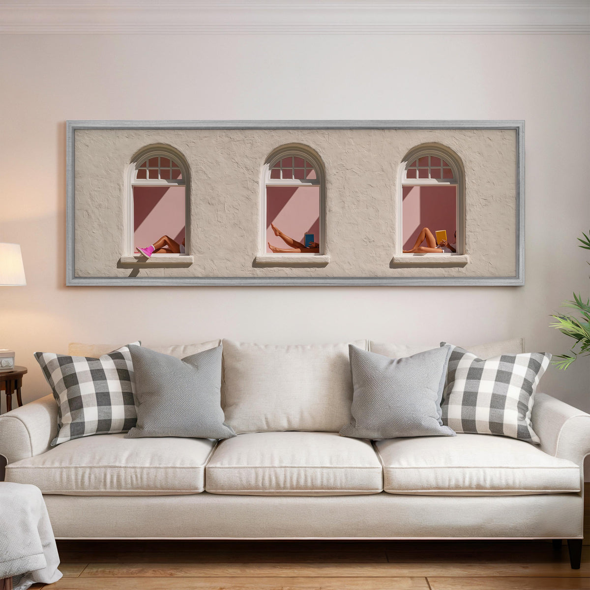 Women reading in three arched windows panoramic canvas print above a white sofa in a bright living room