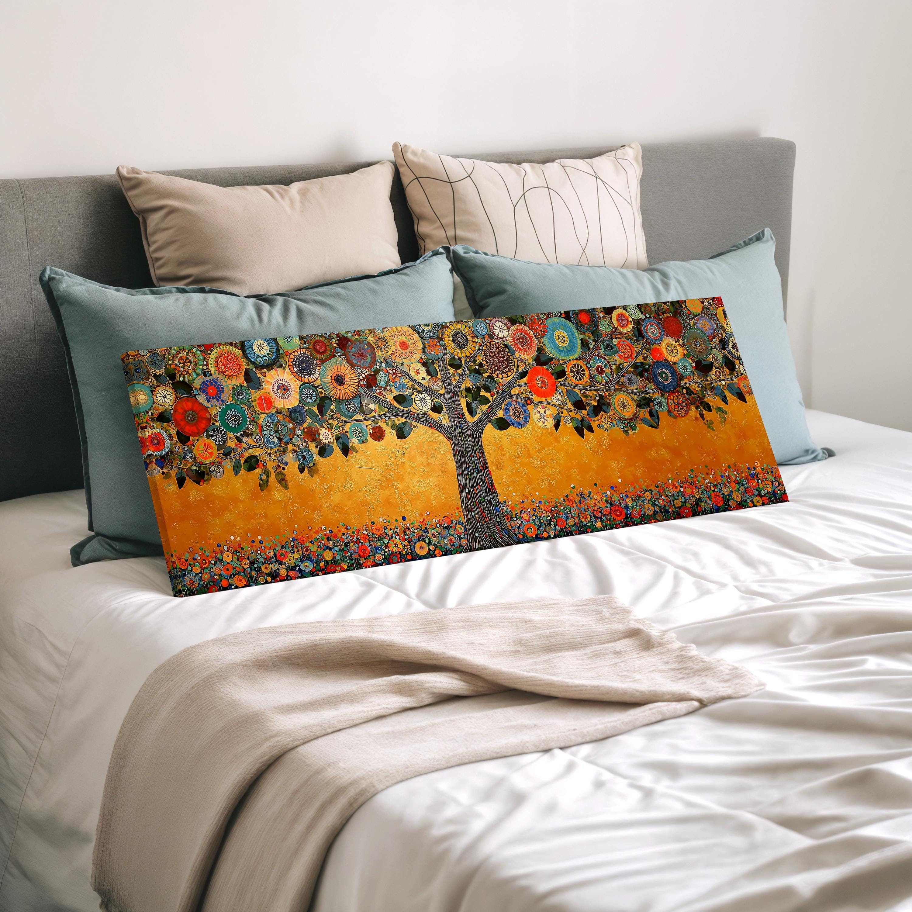 a bed with a large, colorful painting of a tree on it, surrounded by various decorative pillows.