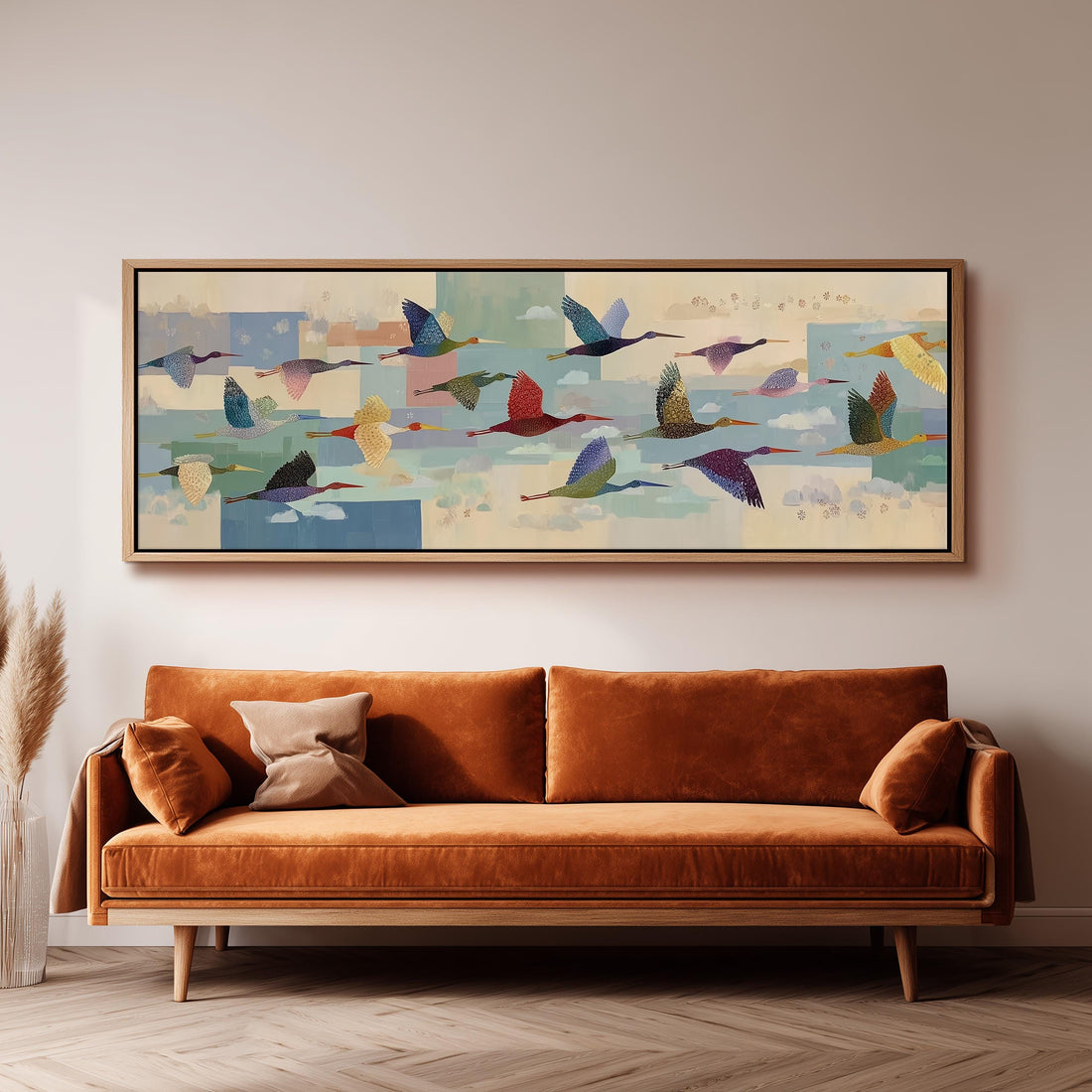 a large, colorful painting of birds in flight hanging on a wall above a brown sofa.