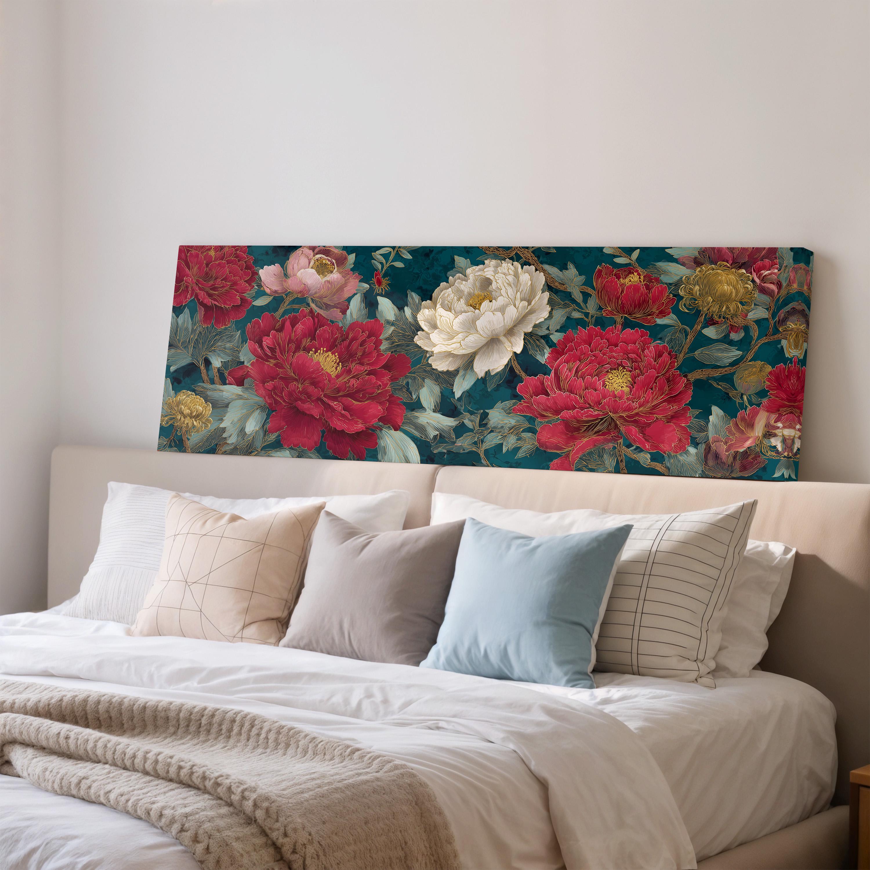a large floral print on the wall above a bed with white pillows and a gray blanket.