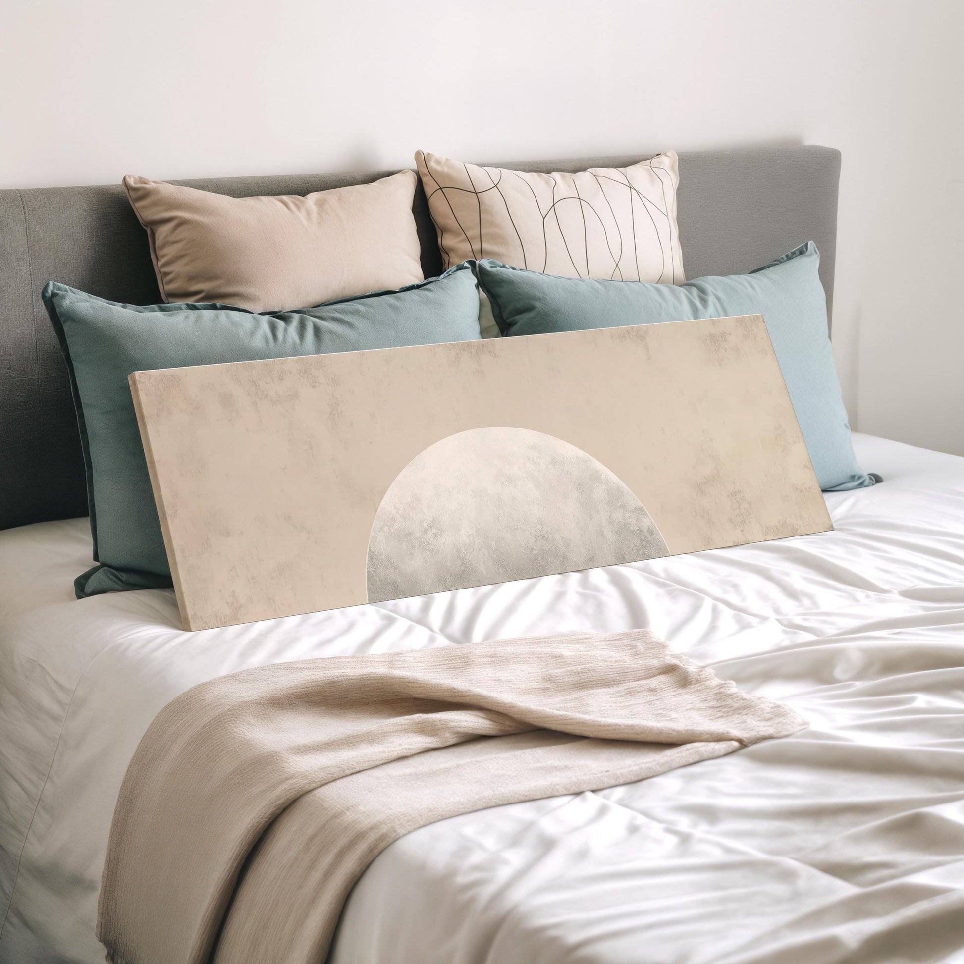 a neatly made bed with a white comforter and a large beige-colored canvas or painting placed on top of it.