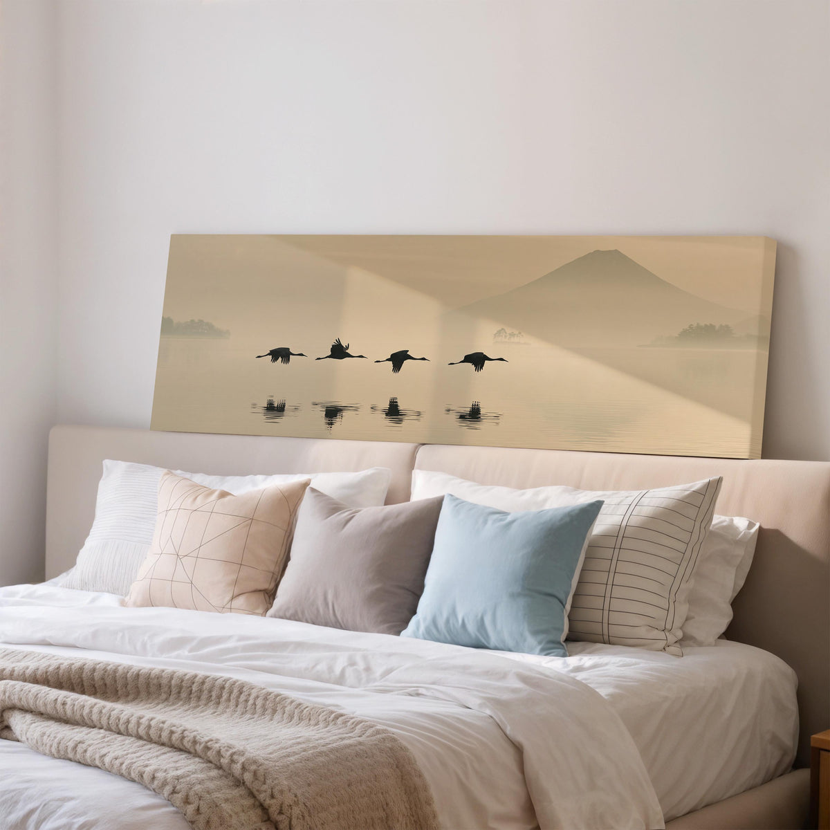 Birds flying low over a lake below Mount Fuji wide panoramic canvas print above a bed in a bedroom