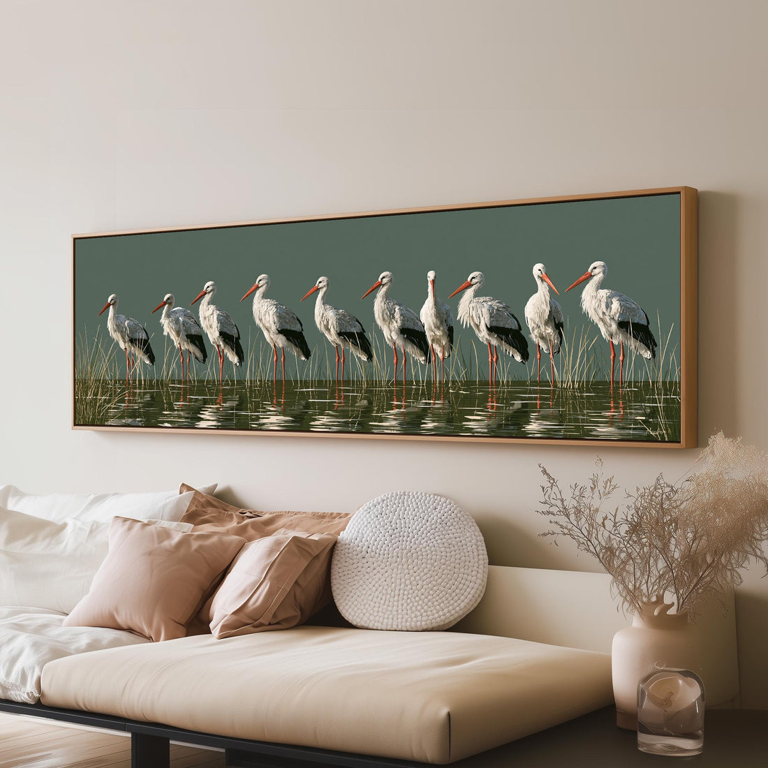 Flock of storks with coral beaks on sage long horizontal canvas print above a sofa in a living room