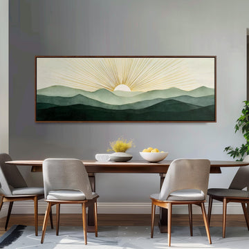 a dining room with a large framed painting of a mountain landscape above a wooden table with four chairs. The painting depicts a serene mountain scene with a sun rising over the horizon.