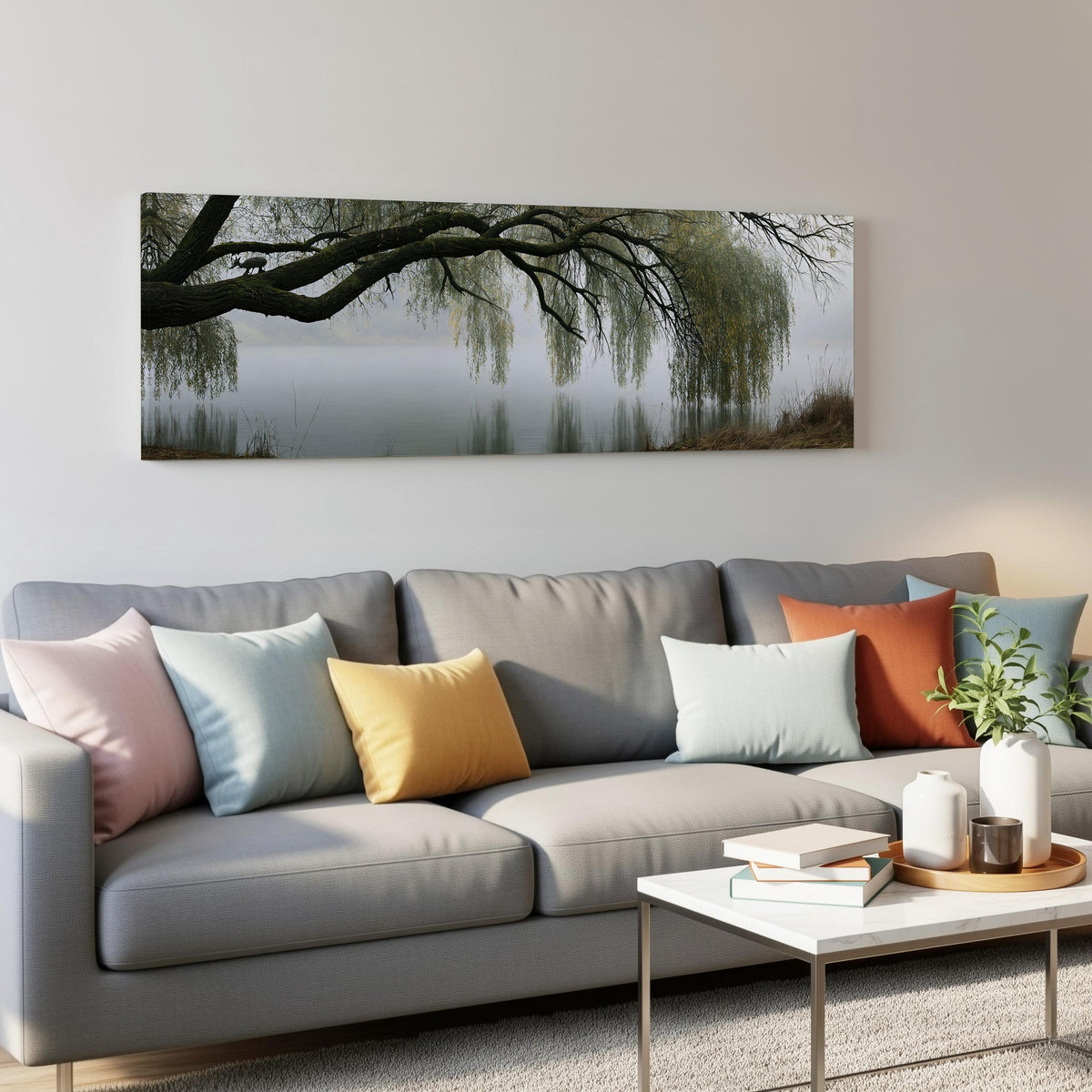 Weeping willow over a misty lake panoramic canvas print above a grey sofa in a living room
