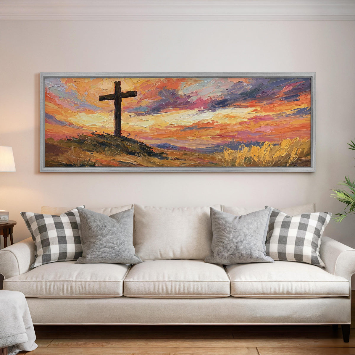 Cross on a hill at sunset panoramic canvas print above a white sofa in a bright living room