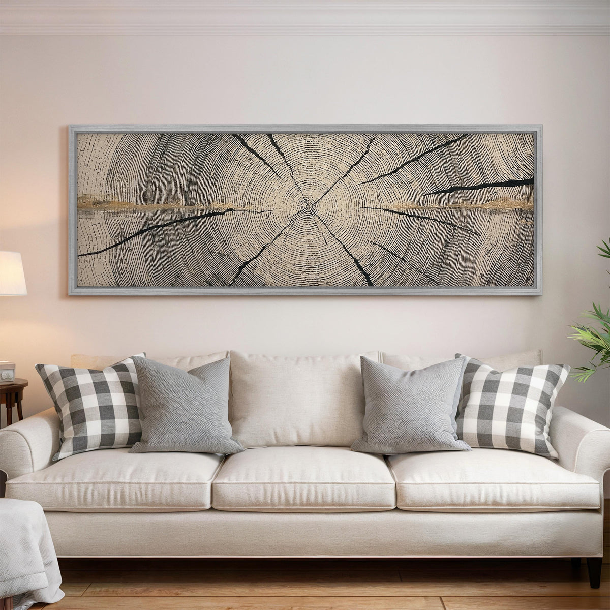 Pale gold wood ring panoramic canvas print above a white sofa in a bright living room