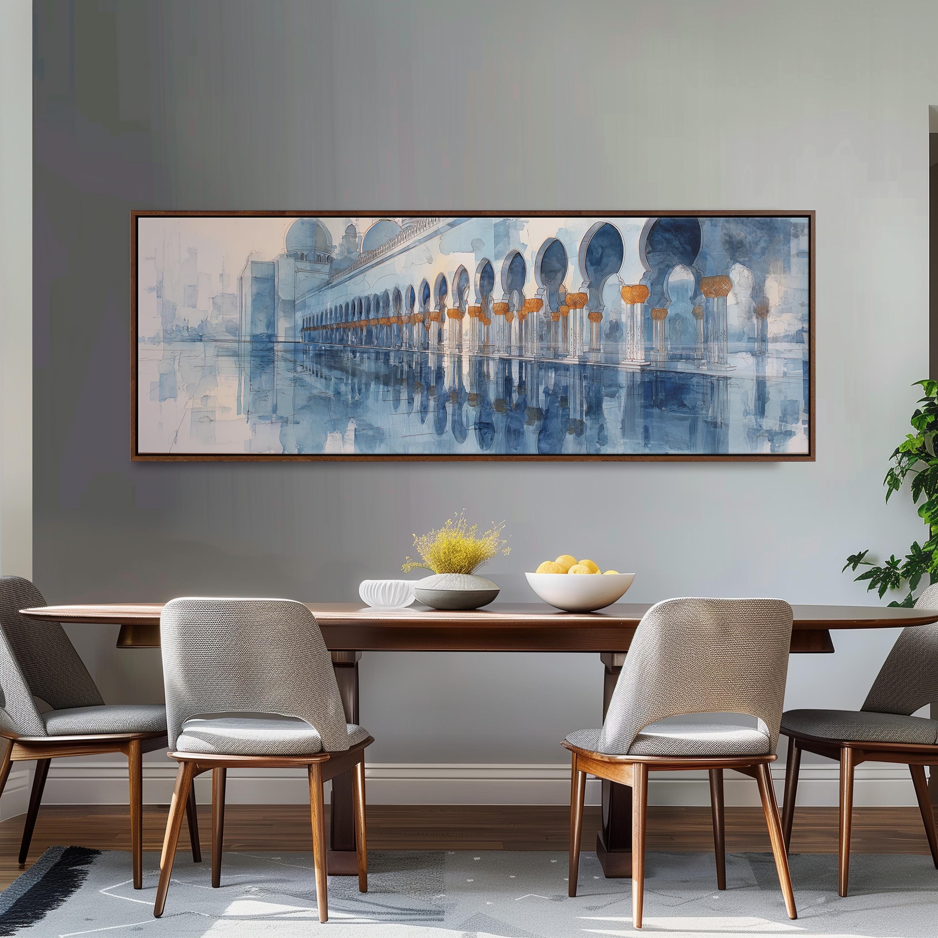 a dining room with a large painting of a building hanging on the wall above a wooden table with four chairs. The table is set with a bowl of fruit and a vase of flowers, creating a cozy and inviting atmosphere.