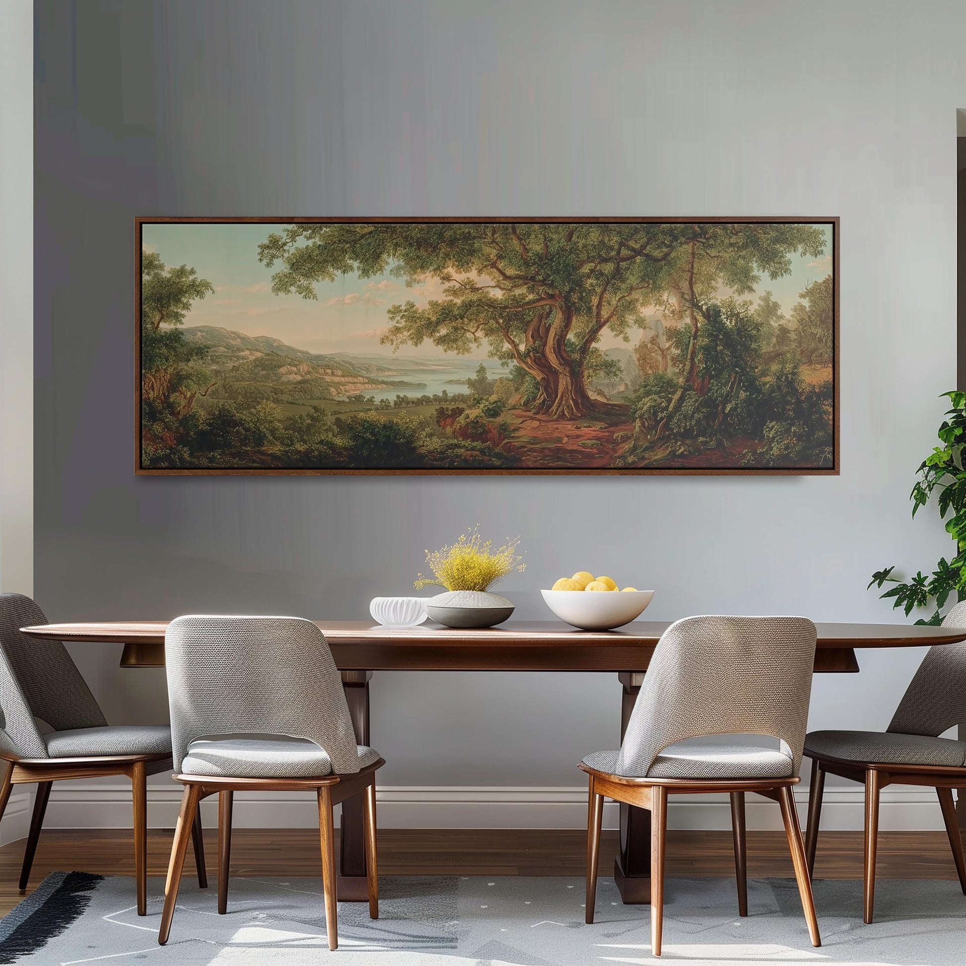 a dining room with a large painting of a forest landscape hanging on the wall above a wooden dining table with four chairs. The table is set with a bowl of fruit and a vase of flowers, creating a cozy and inviting atmosphere.