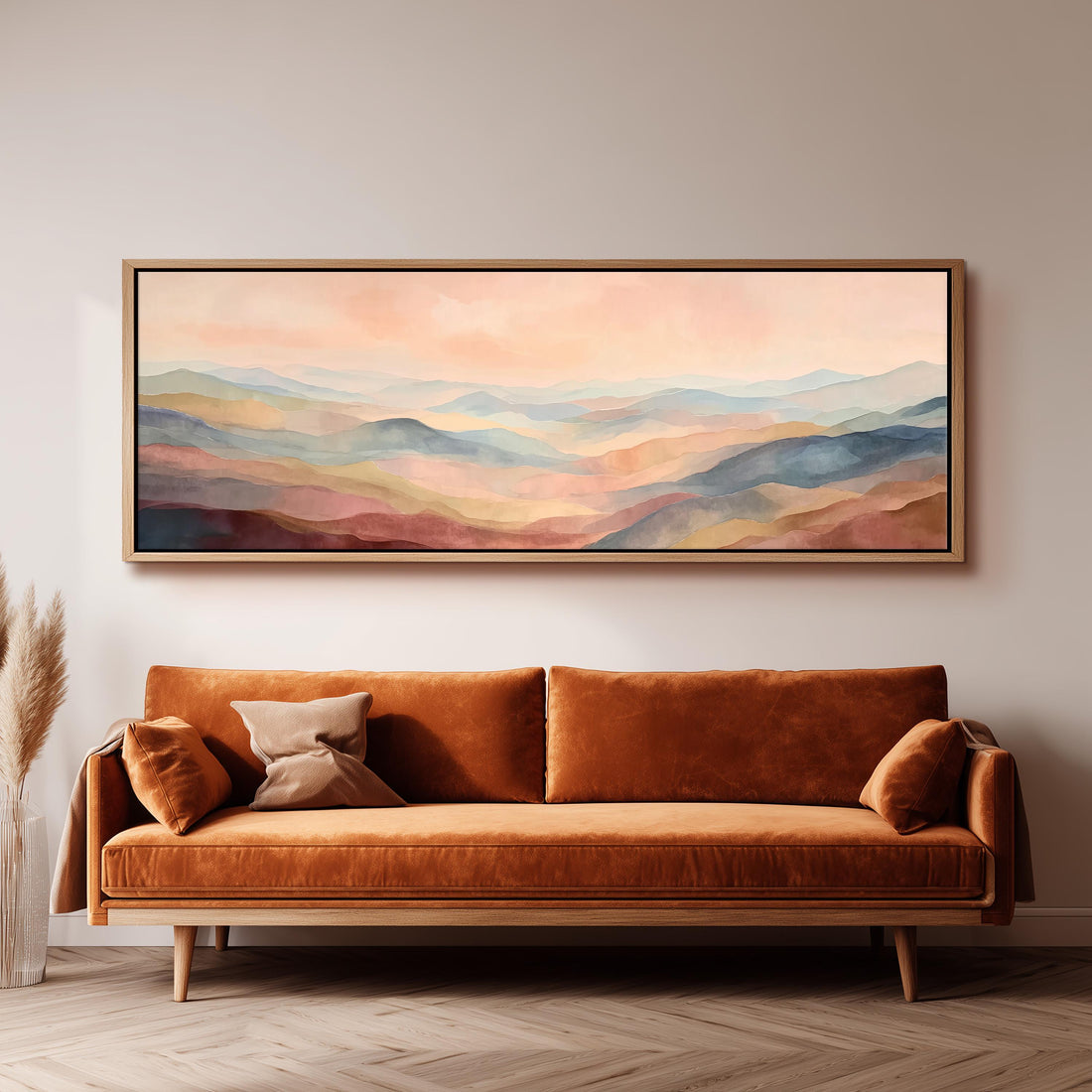 a large, rectangular painting hanging on a wall above a brown sofa with two pillows.