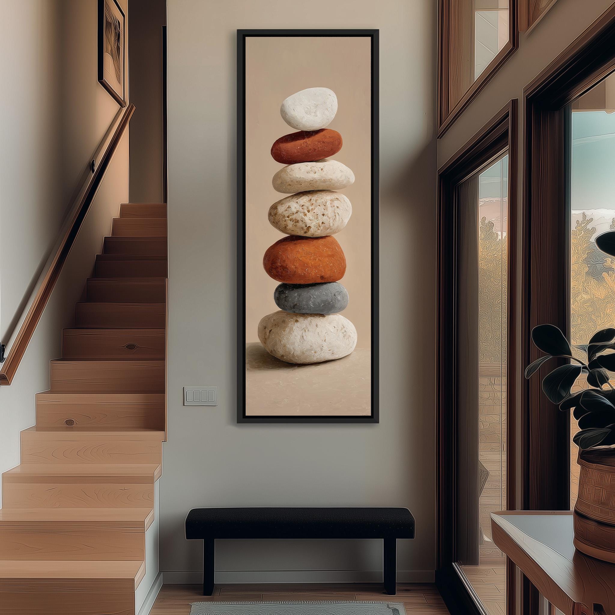 a large framed picture of a stack of rocks on the wall, with a wooden staircase and a bench in the foreground.