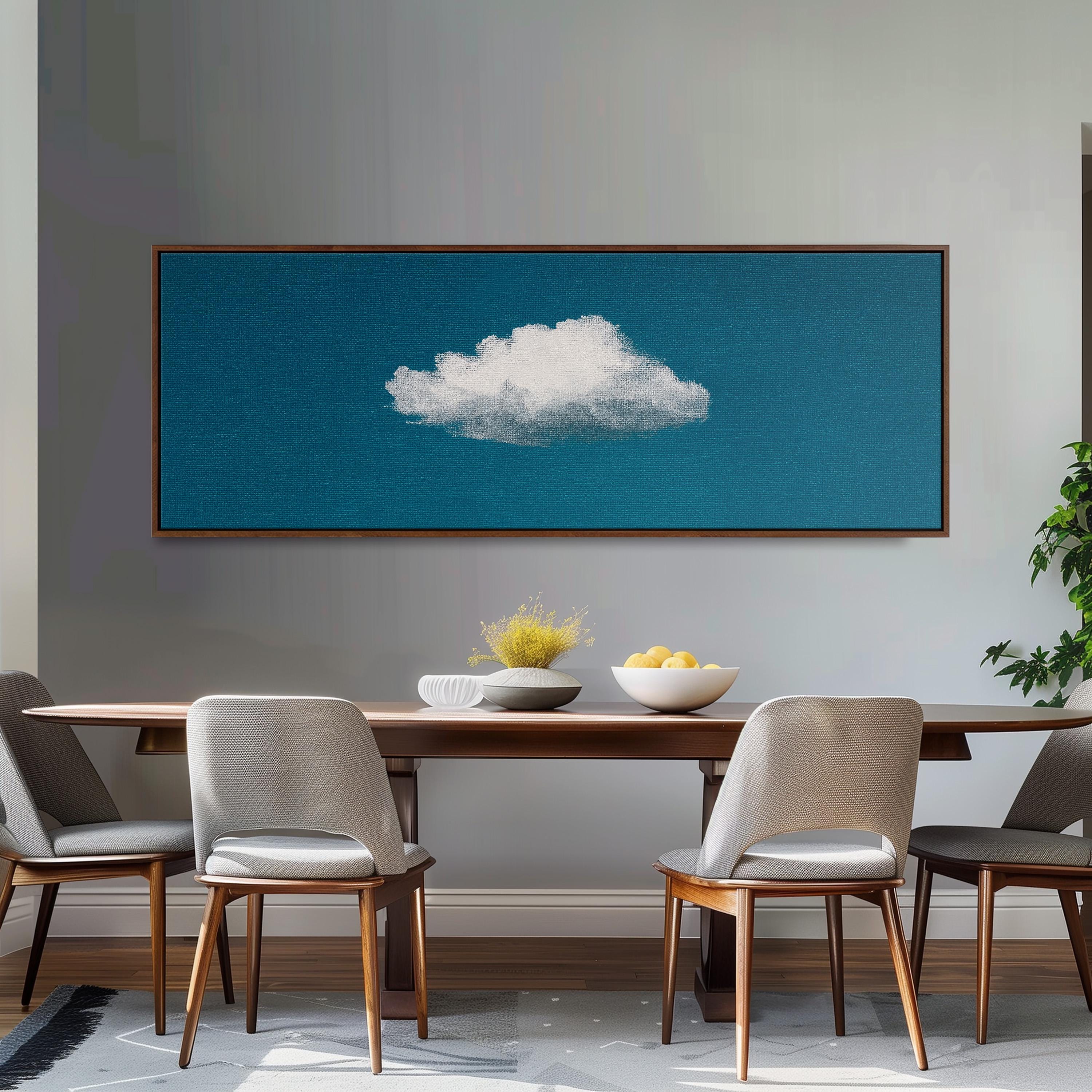 a dining room with a wooden table and four chairs, a large framed artwork of a cloud on the wall above the table, and a bowl of fruit on the table.