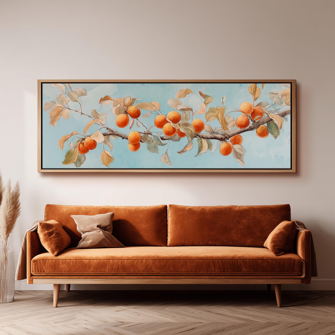 a large painting of a branch with oranges hanging from it, hanging on a wall above a brown sofa.