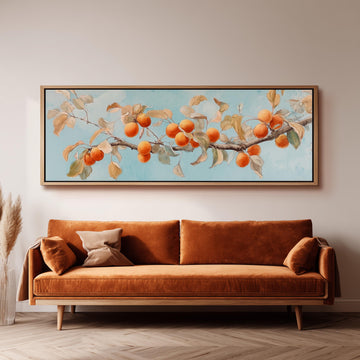 a large painting of a branch with oranges hanging from it, hanging on a wall above a brown sofa.