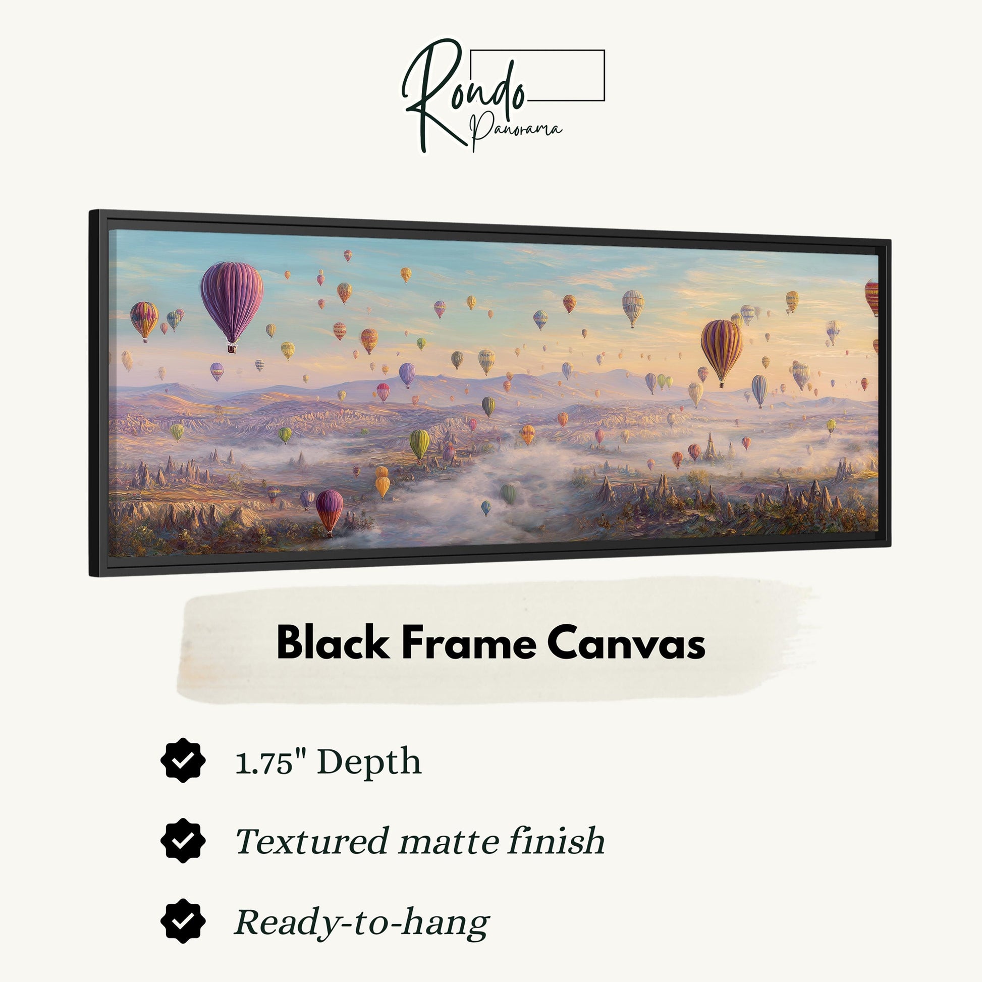 A black frame canvas depicting a vibrant scene of hot air balloons floating over a mountainous landscape.