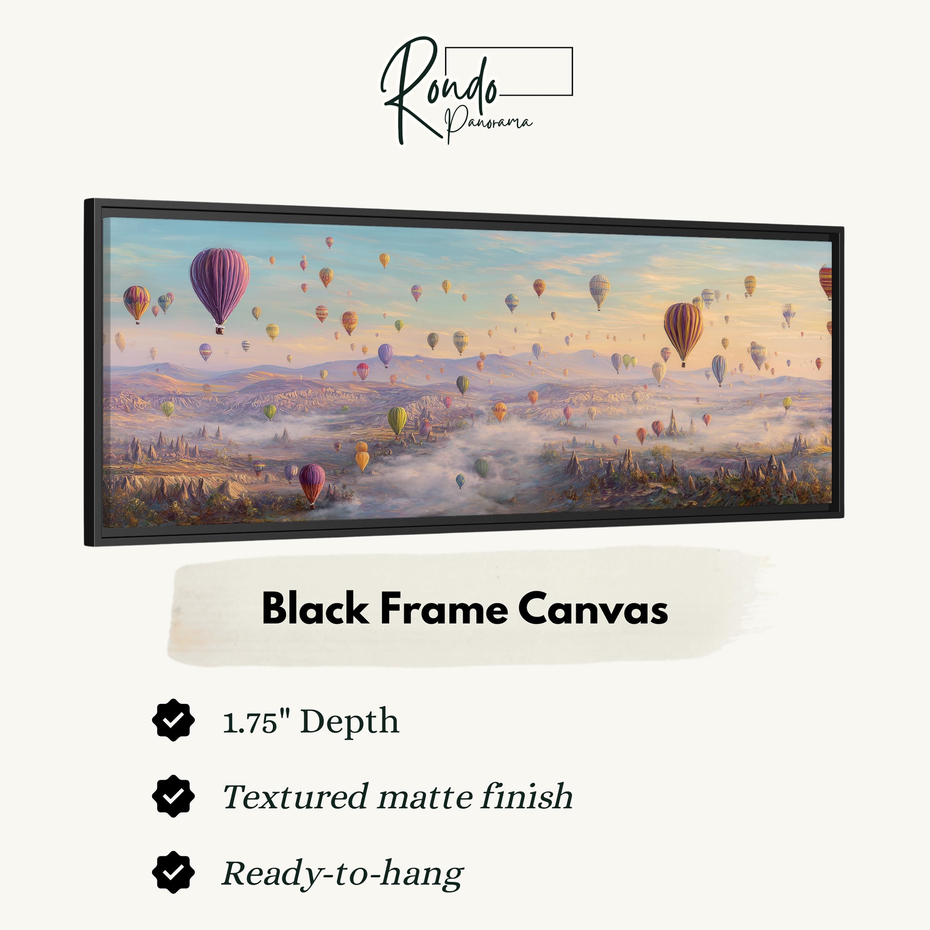 A black frame canvas depicting a vibrant scene of hot air balloons floating over a mountainous landscape.