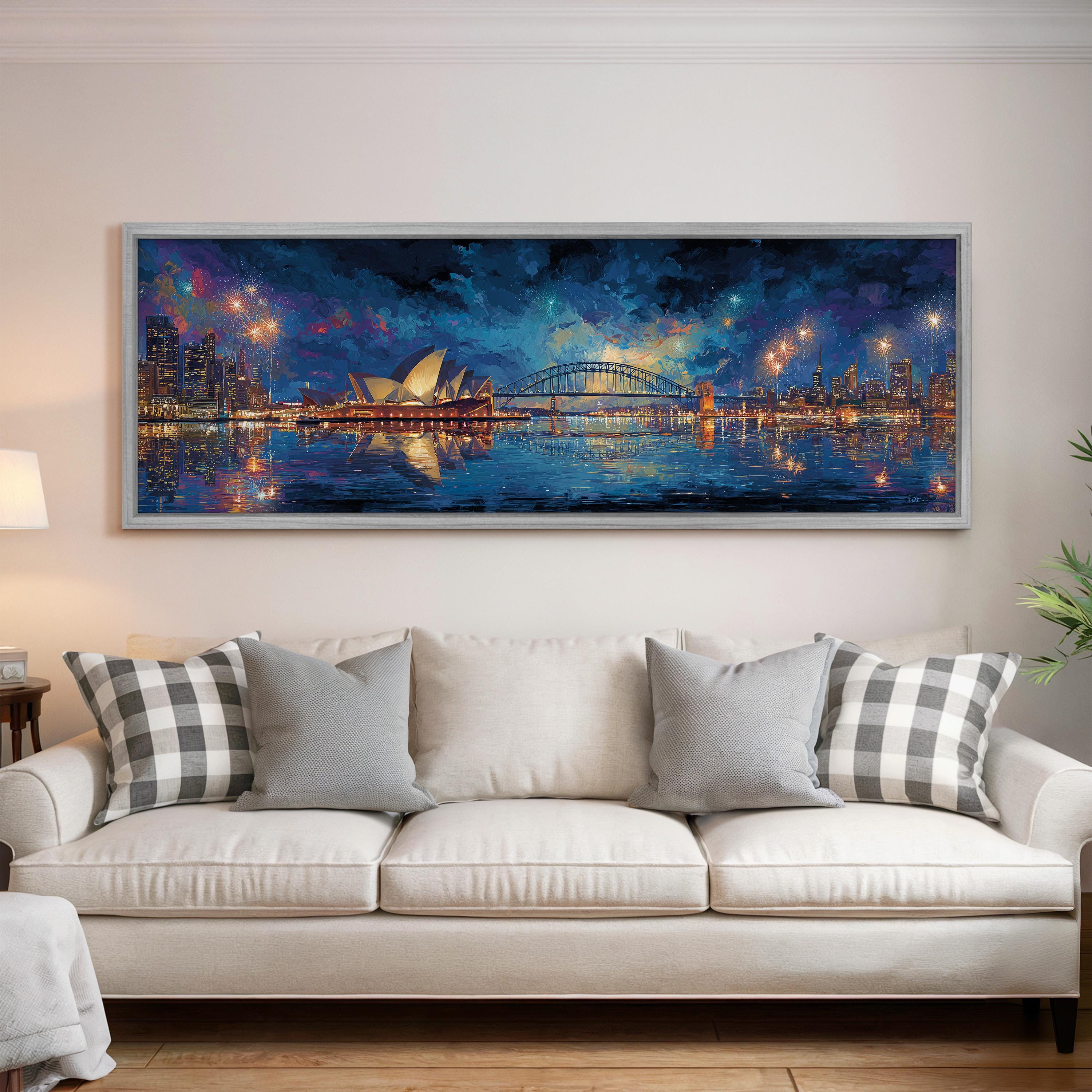 a large, framed painting of the Sydney Opera House and the city skyline at night, hanging on a wall above a white couch with patterned throw pillows.