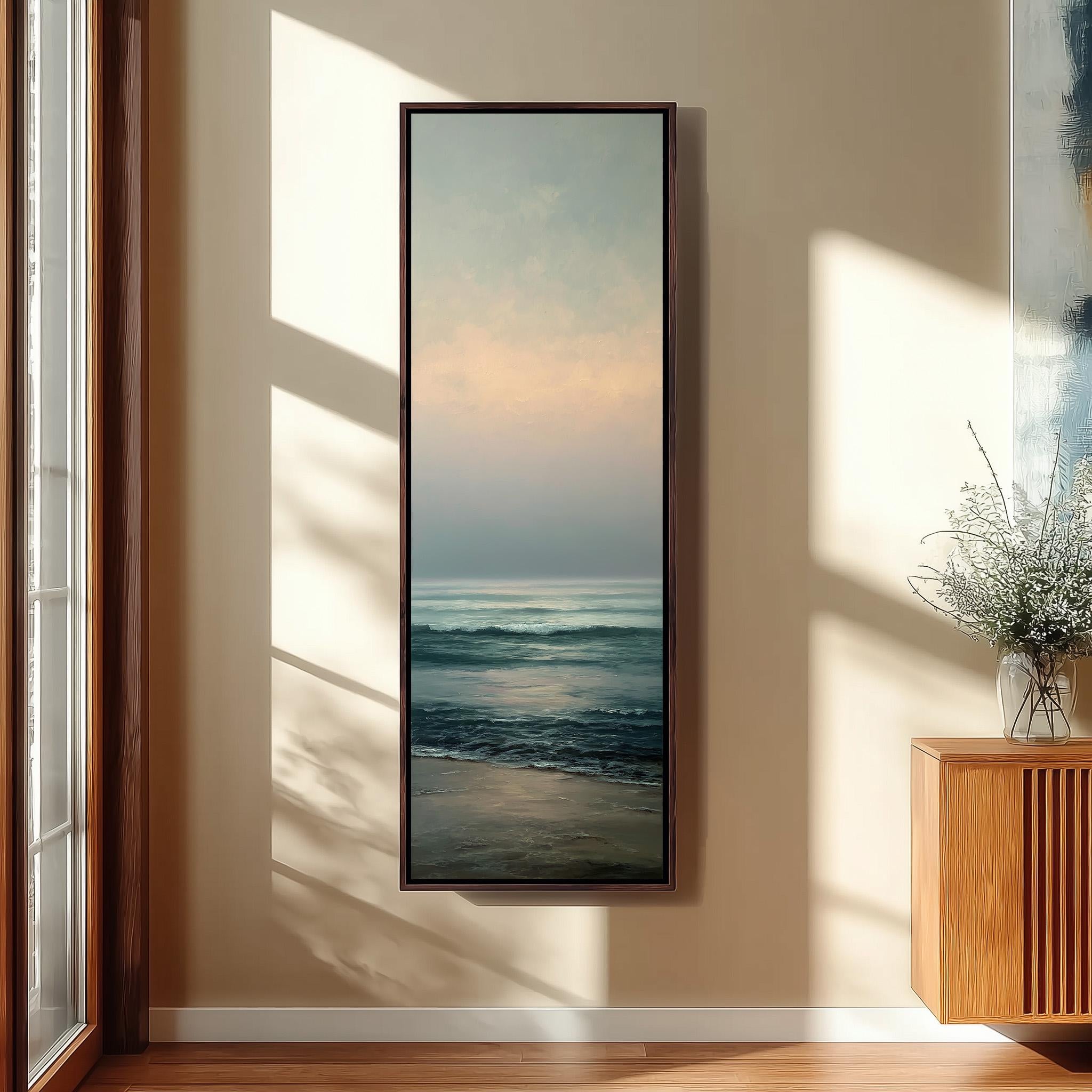a large framed painting of a serene ocean scene hanging on a wall, with a wooden cabinet and a vase of flowers to the right of the painting.