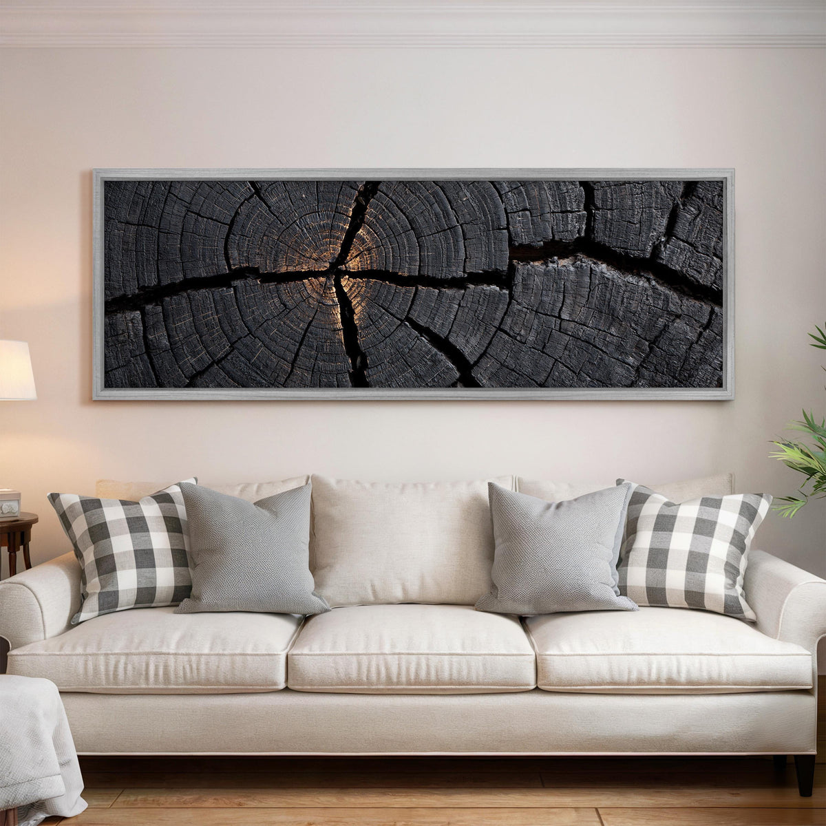 Charcoal tree ring cross section panoramic canvas print above a white sofa in a bright living room