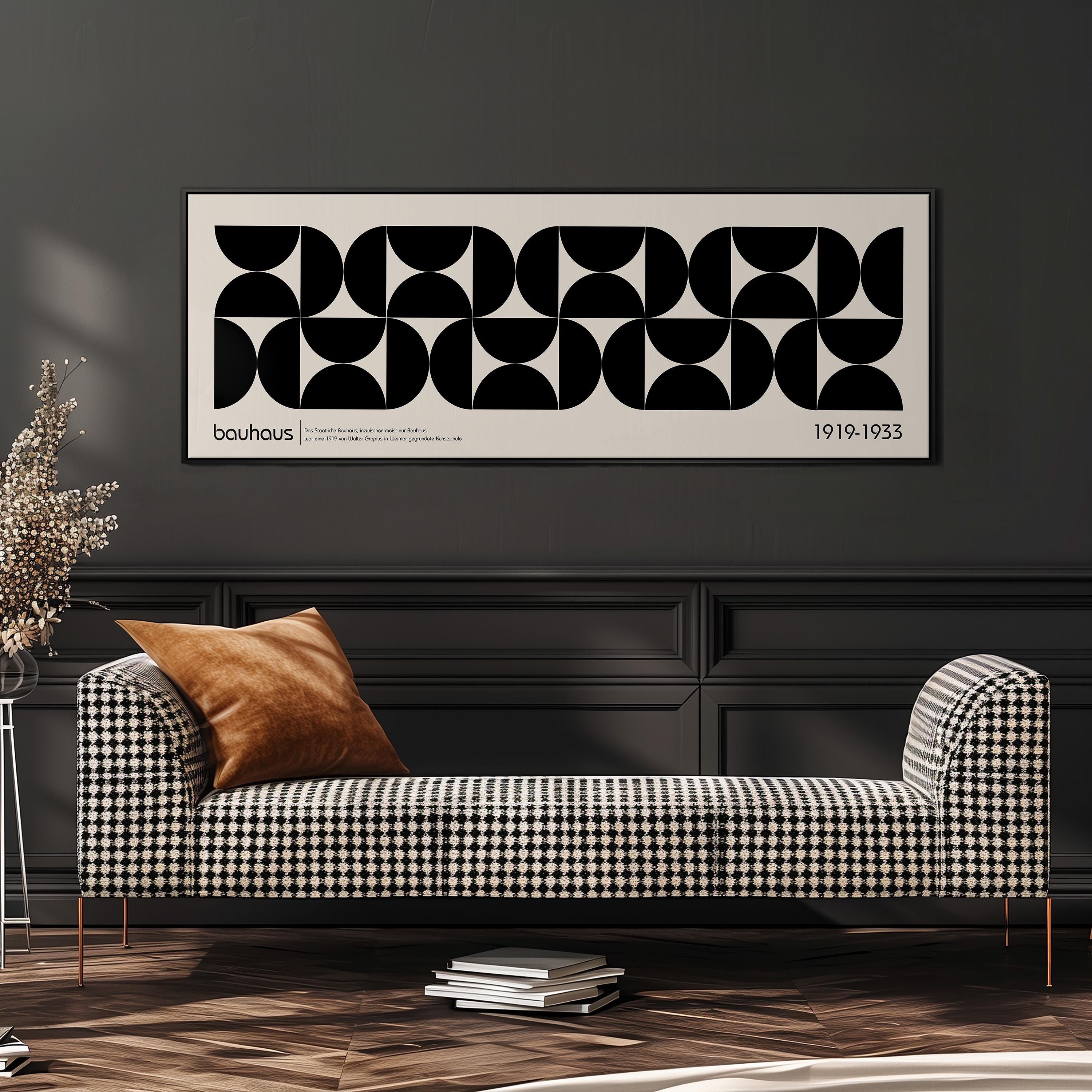a modern black and white checkered sofa with a brown throw pillow, set against a dark wall with a framed abstract art piece above it.