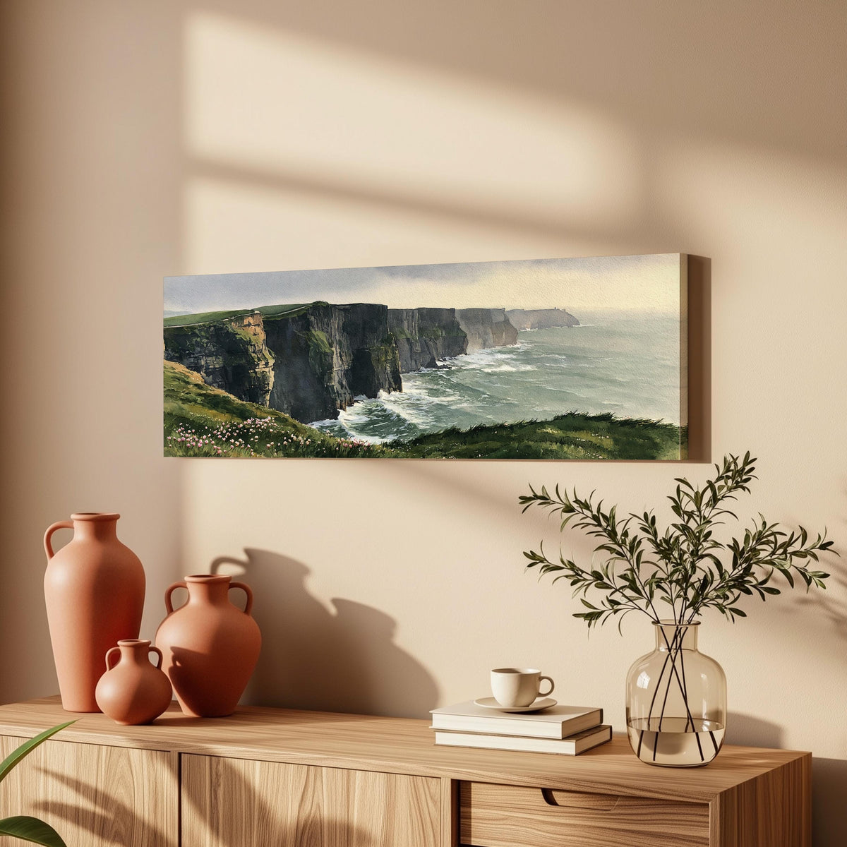 Green sea cliffs with wildflowers long horizontal canvas print above a wooden sideboard