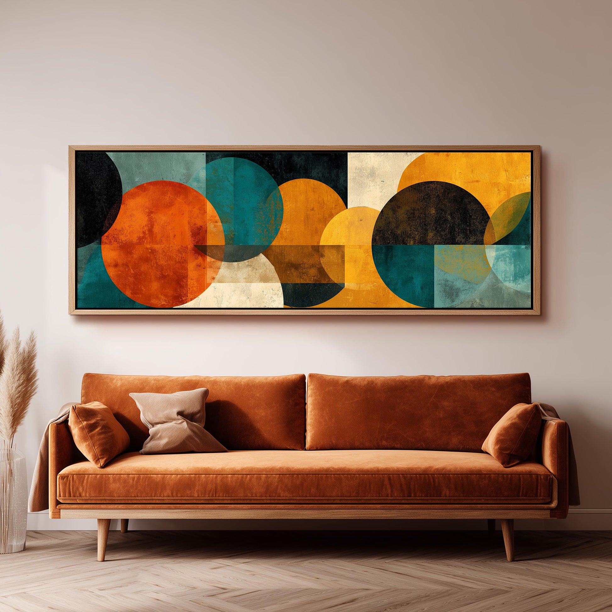 a large abstract painting hanging on a wall above a brown sofa in a living room setting.