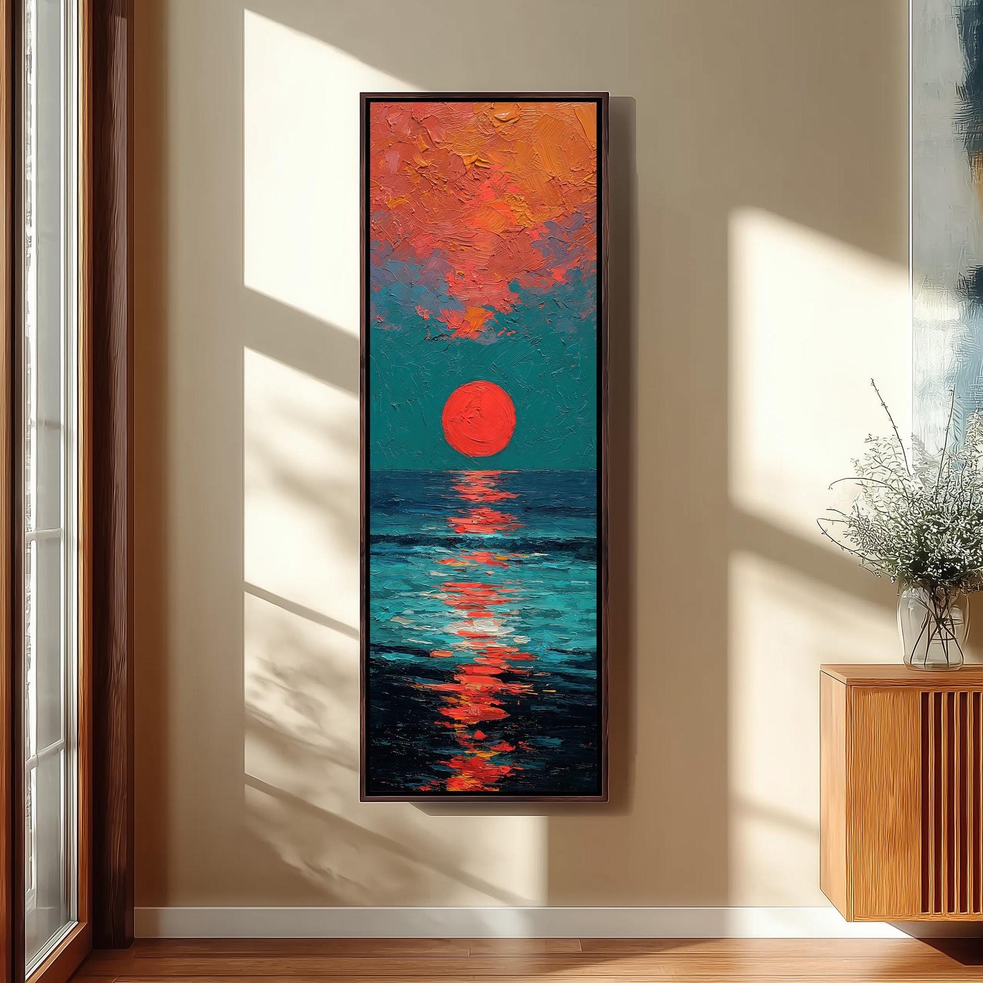 a large, colorful painting of a sunset over the ocean, hanging on a wall in a room with a wooden cabinet and a vase of flowers.