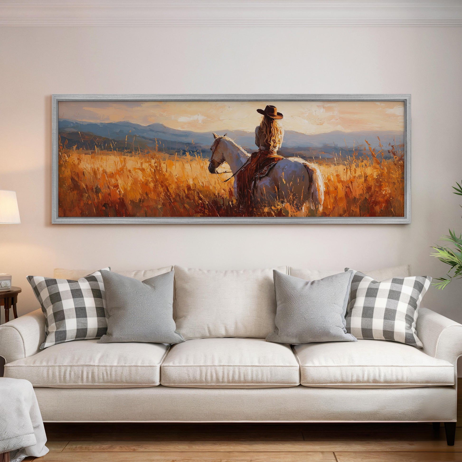 a large painting of a woman riding a horse in a field, with mountains in the background.