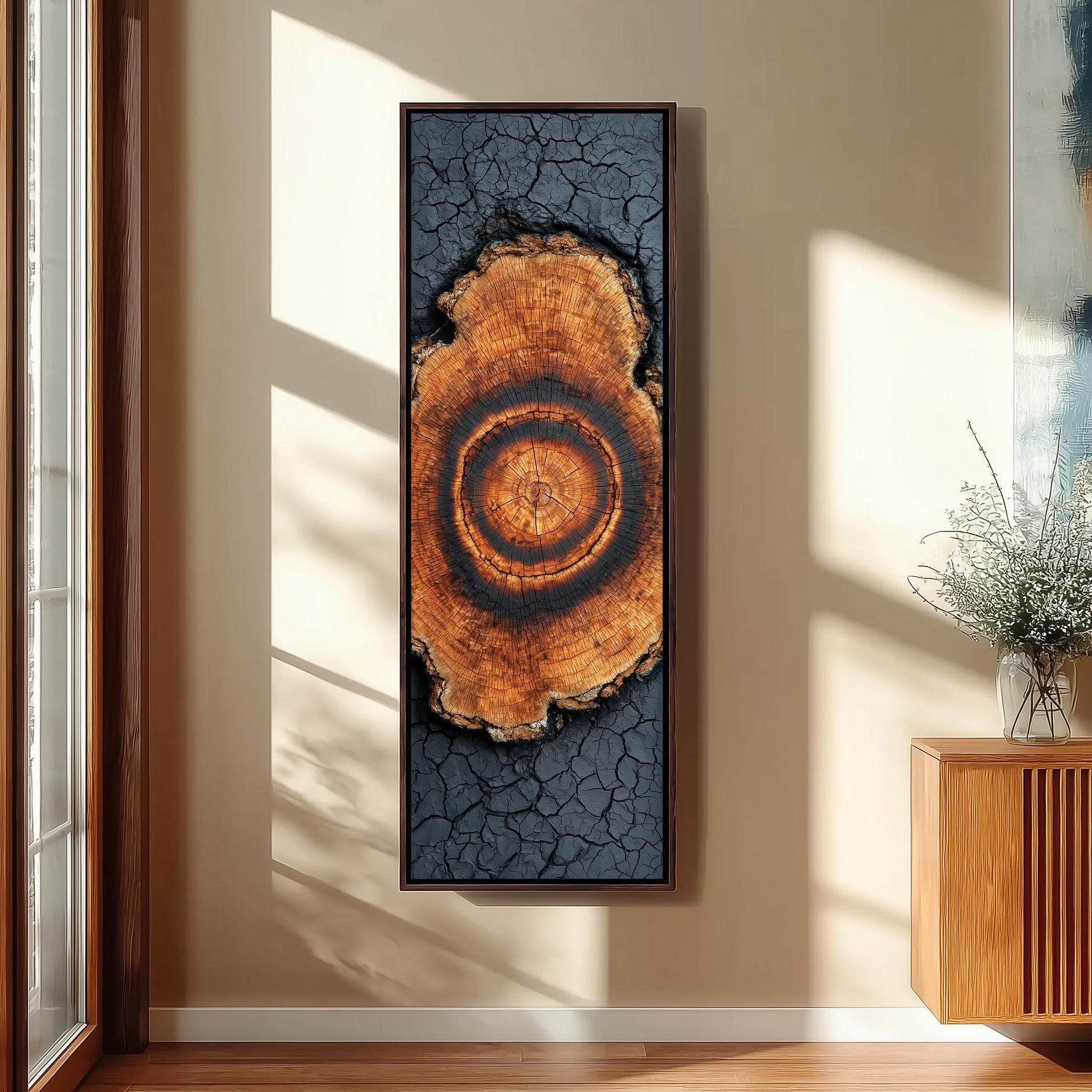 a large, framed artwork hanging on a wall, depicting a tree trunk with a circular pattern.