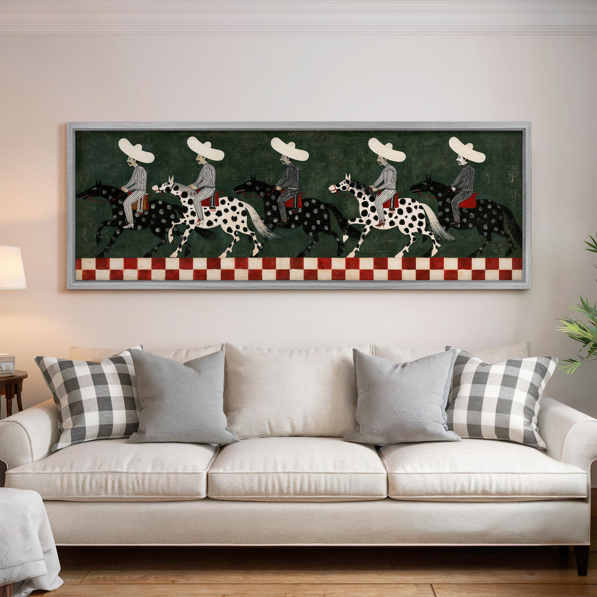 Riders in sombreros on spotted horses panoramic canvas print above a white sofa in a bright living room