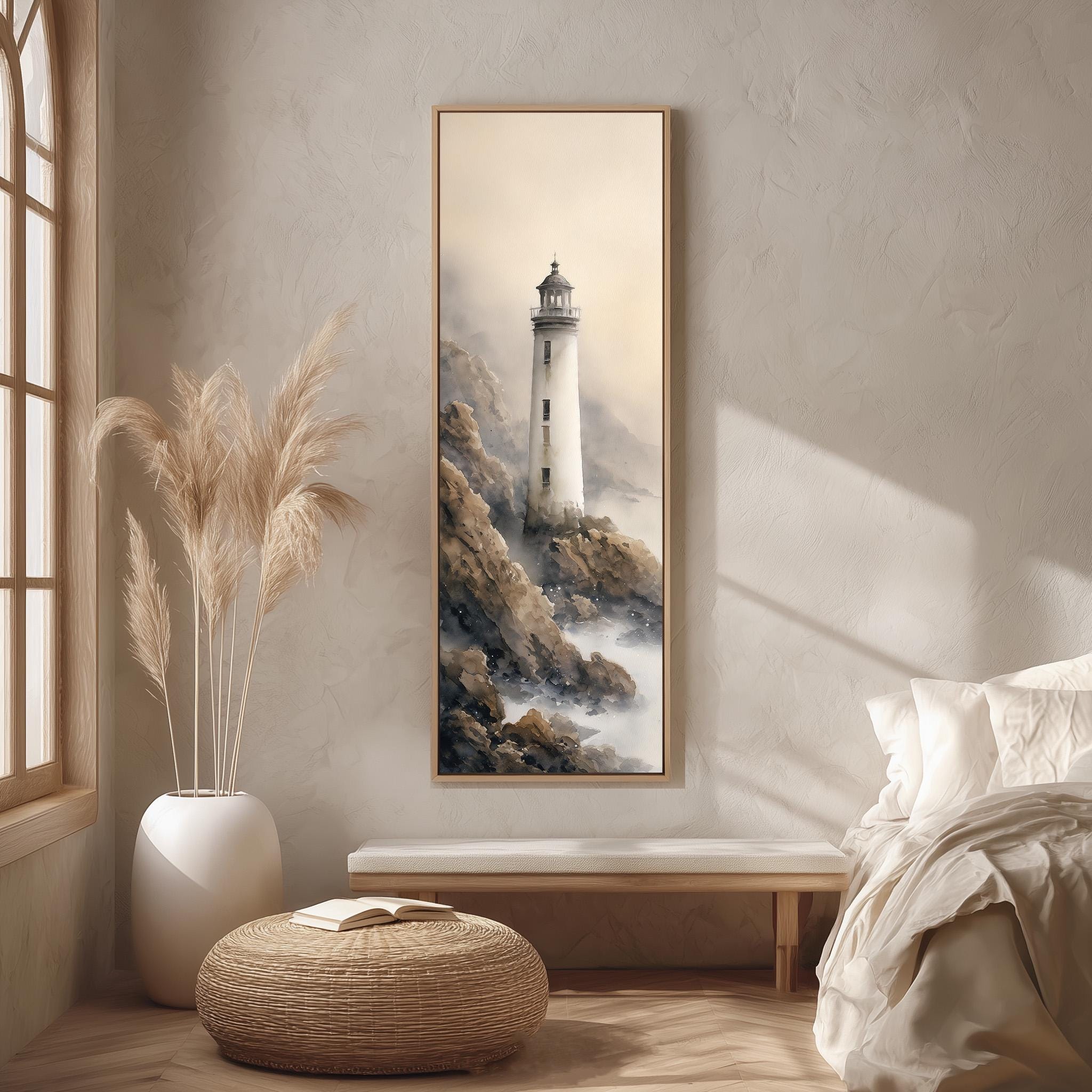 a serene bedroom scene with a large framed painting of a lighthouse on the wall, a white bed with a white pillow, a white vase with tall reeds, and a woven ottoman.