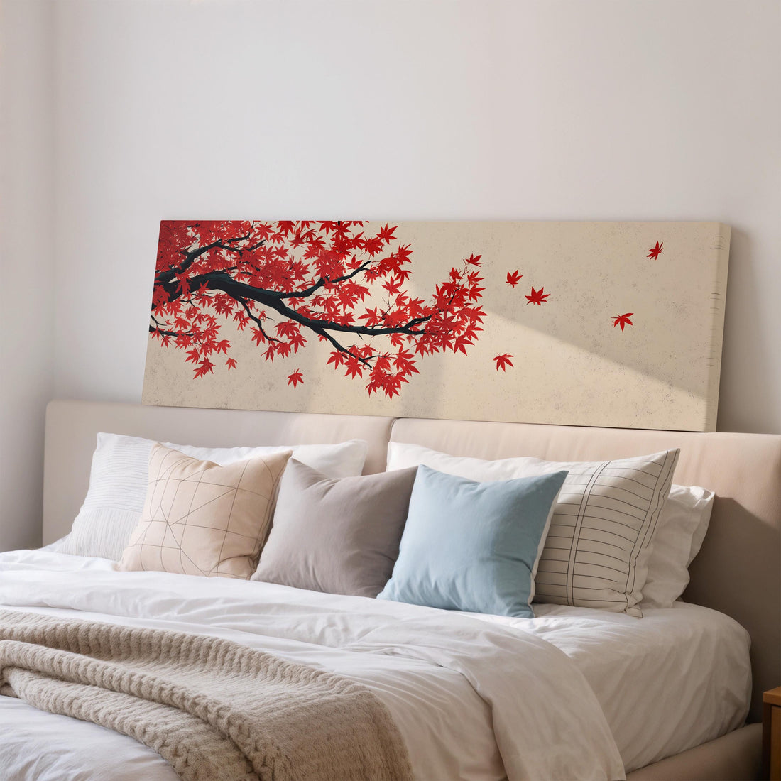 a large bed with a white comforter and pillows, and a large canvas print of a tree with red leaves hanging above it.