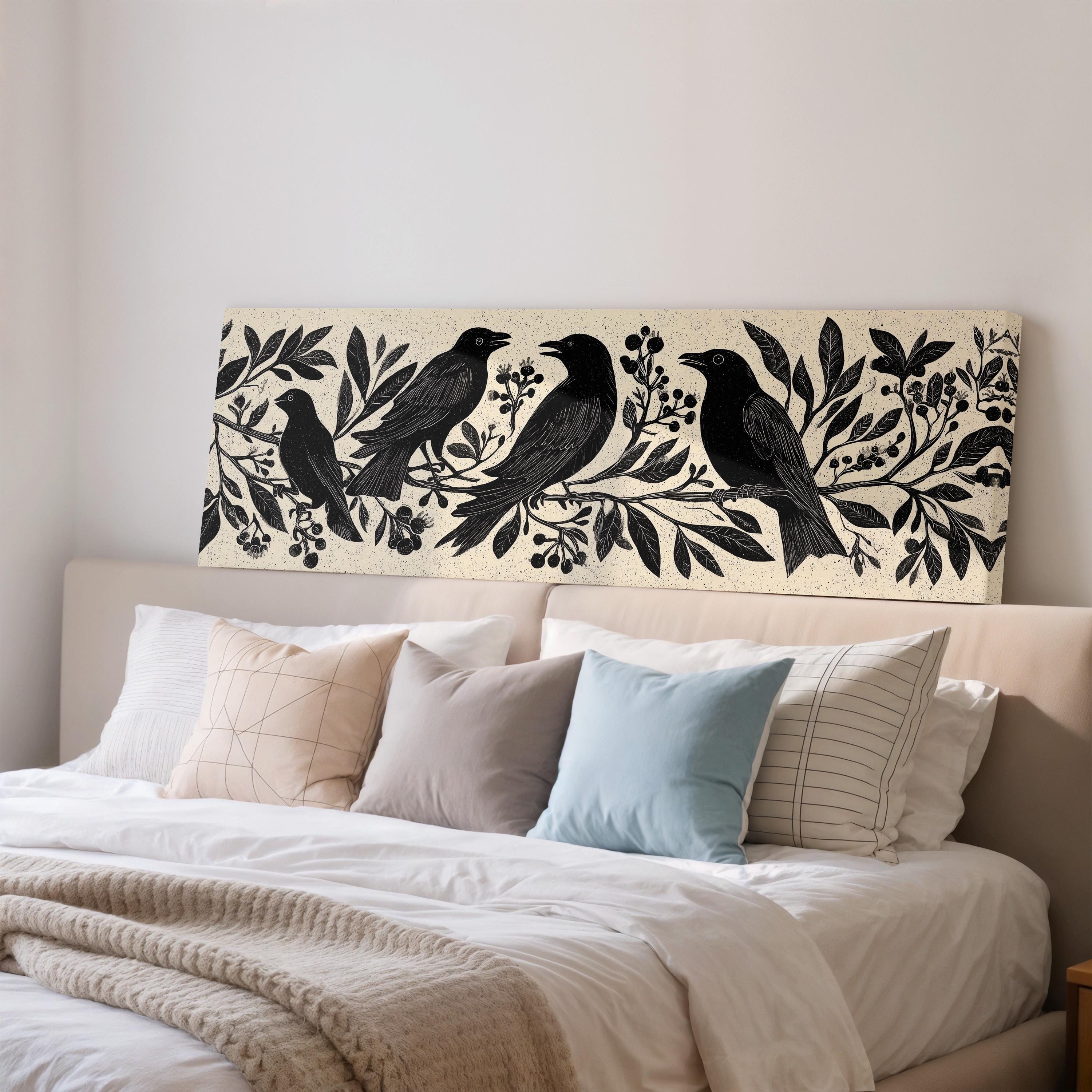 a bedroom with a bed adorned with white linens and a beige blanket. Above the bed, there is a decorative print depicting a group of black birds perched on branches with leaves and berries.