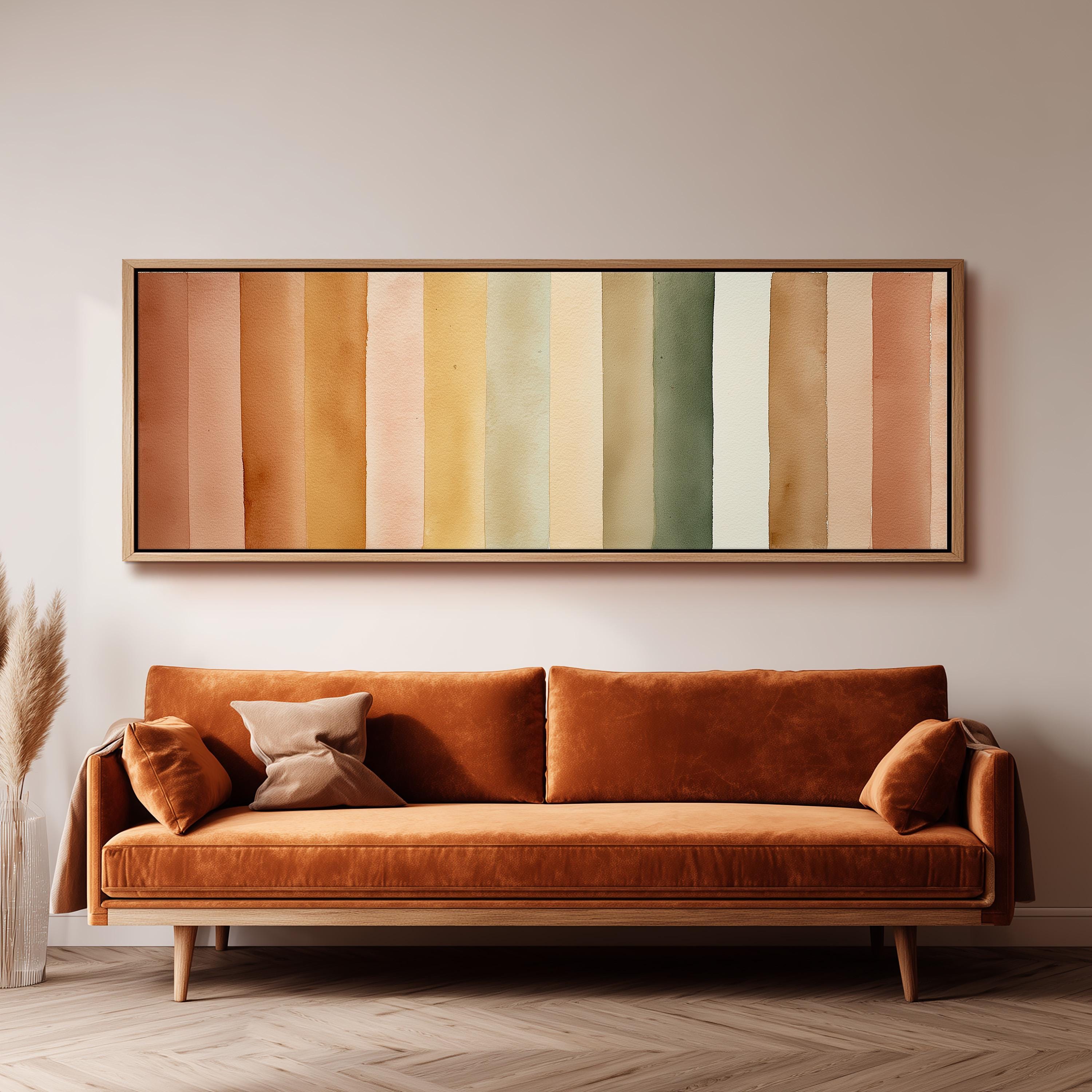 a large, vibrant orange couch with a wooden frame, positioned in front of a wall with a framed abstract painting above it.