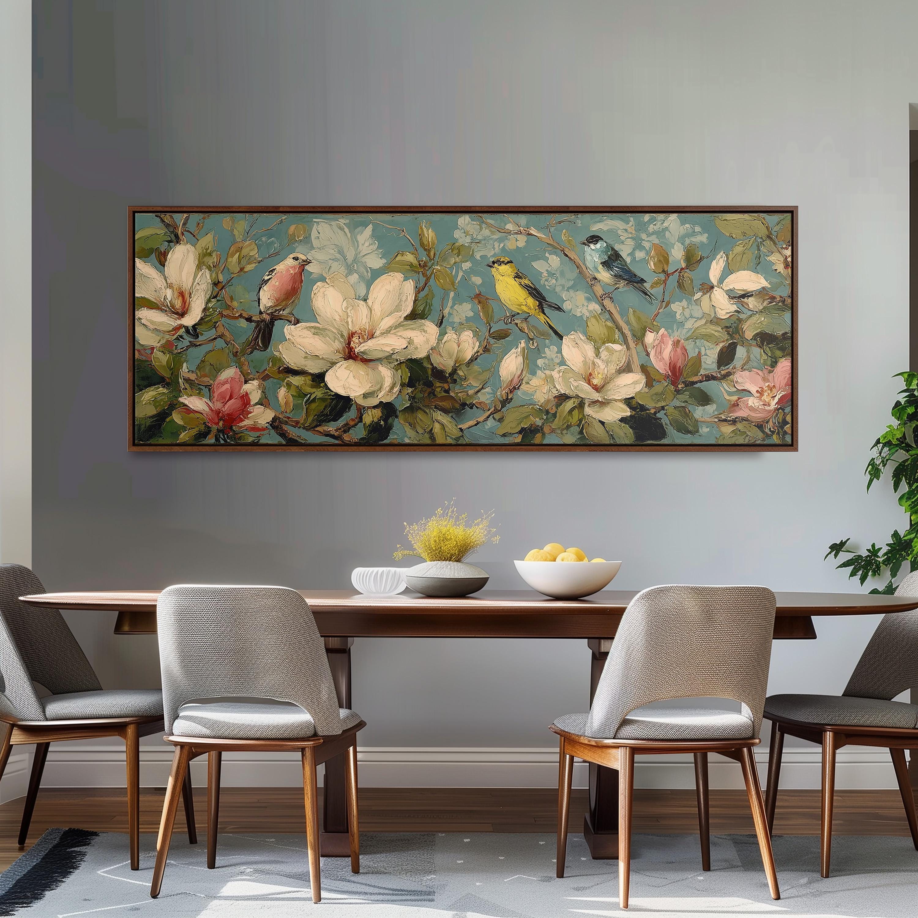 a dining room with a large floral painting hanging on the wall above a wooden table with four chairs. The painting depicts a vibrant scene of birds perched on flowers and branches, creating a lively and colorful atmosphere.