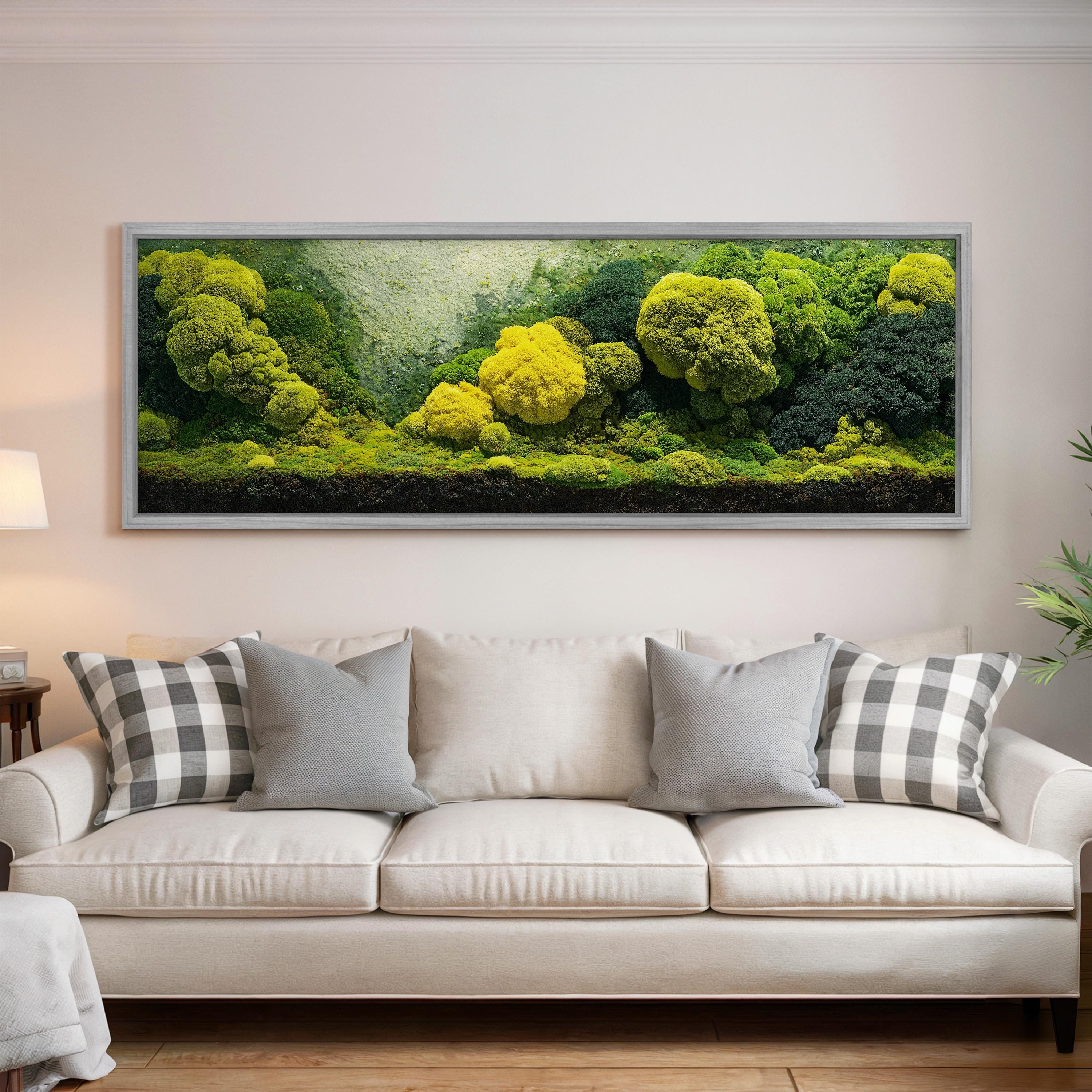 a large, framed painting of a lush, verdant landscape with a variety of trees and foliage, hanging on a wall above a white sofa with patterned throw pillows.