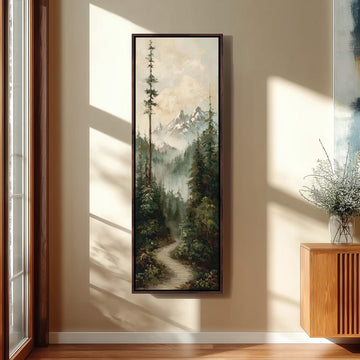 a large painting of a forest scene hanging on a wall, with a wooden cabinet and a vase of flowers placed next to it.
