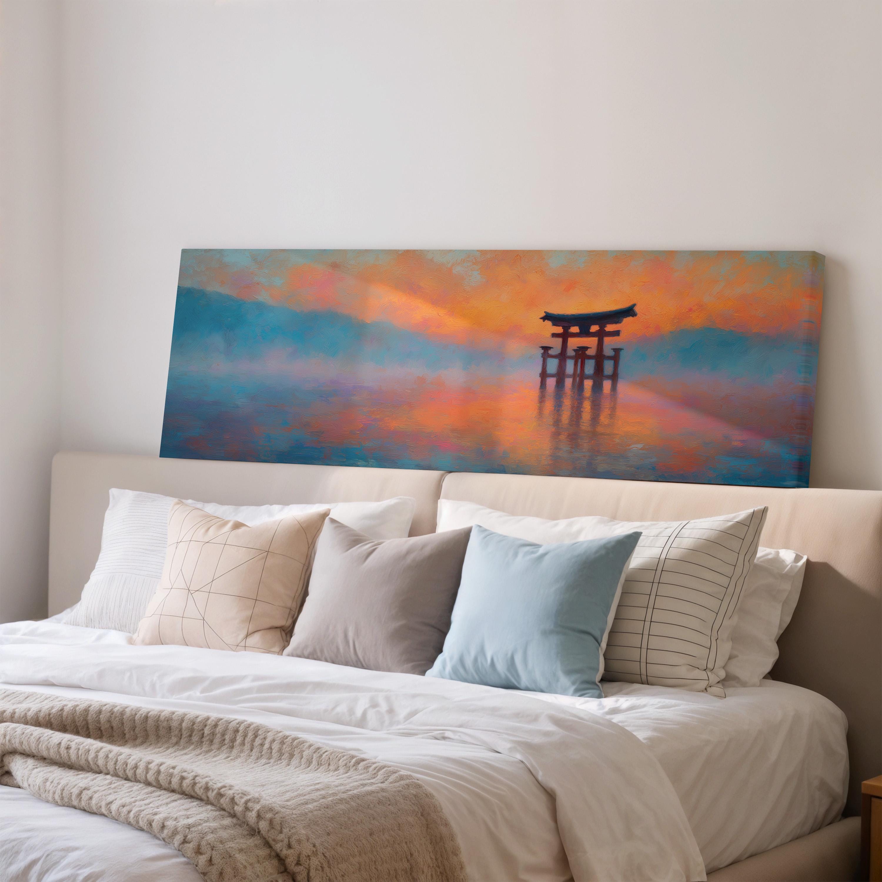 a large painting of a torii gate on a wall above a bed with white pillows and a gray blanket.